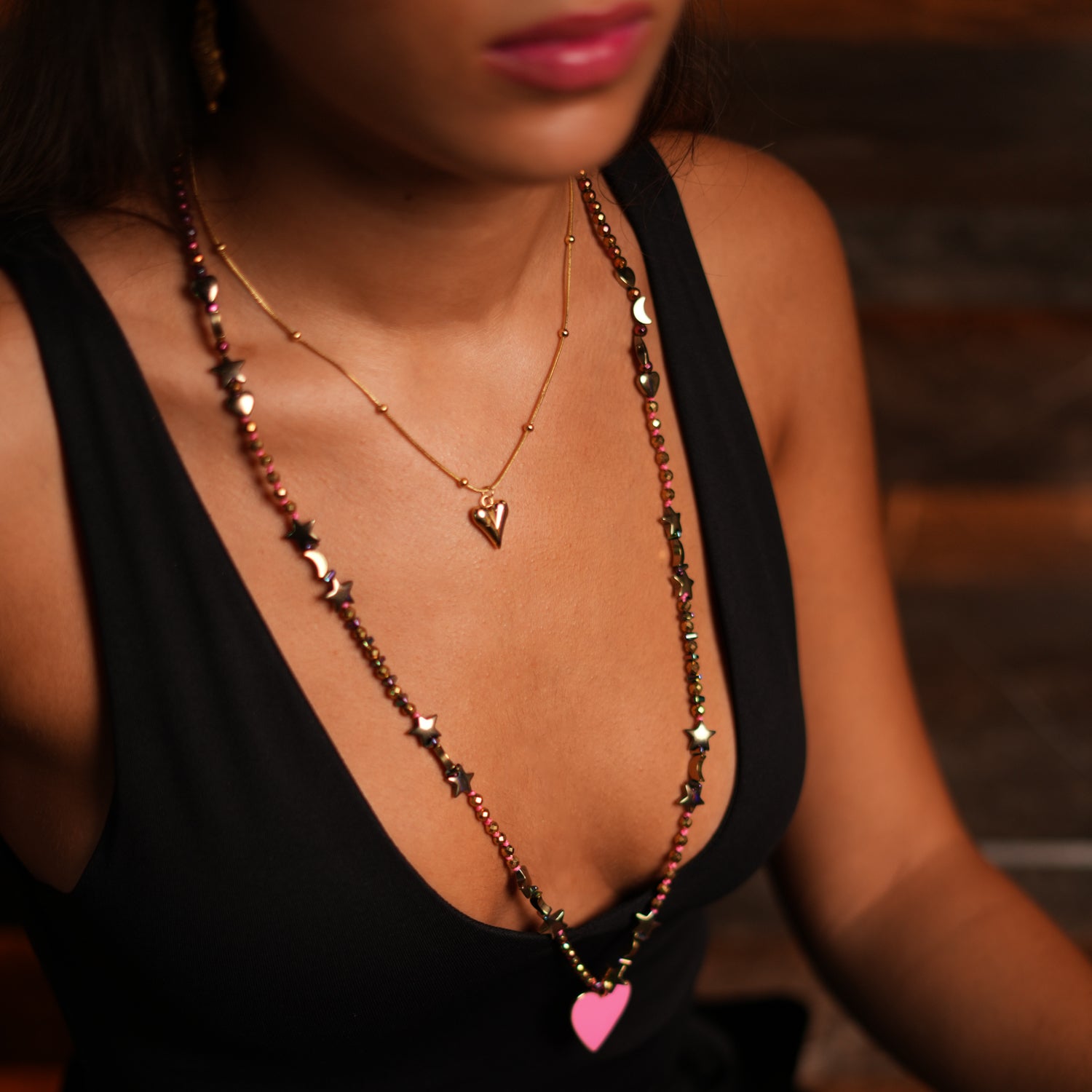 Gold and multicolor hematite necklace with star, moon, and heart beads, complemented by a pink heart pendant.