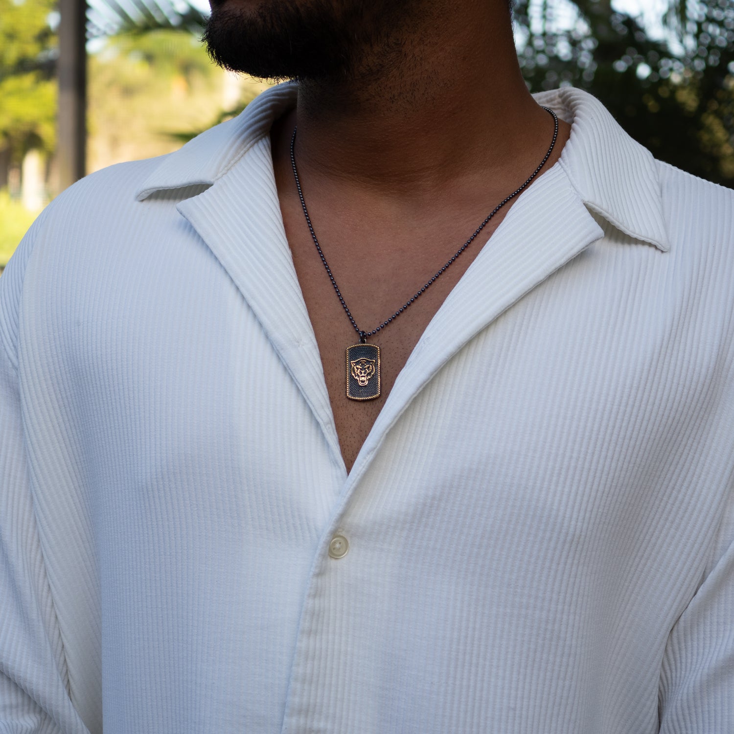 Gold-accented lion head pendant on a 22-inch sterling silver men's chain.