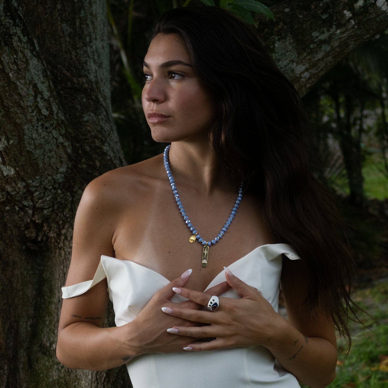 Handmade blue crystal necklace with 18K gold-plated lightning bolt and elephant charms.