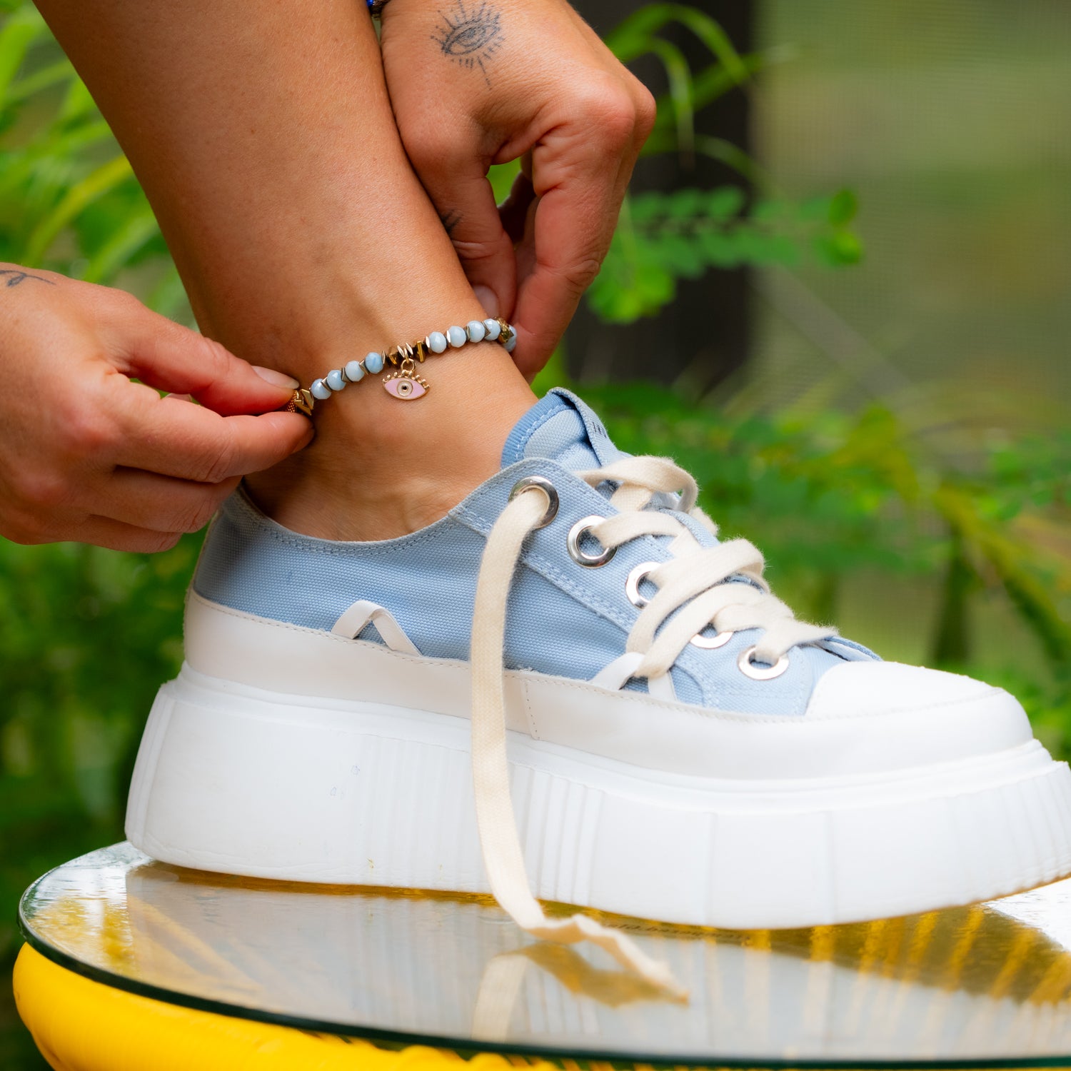 Soft blue crystal anklet with pink and green enamel evil eye beads.
