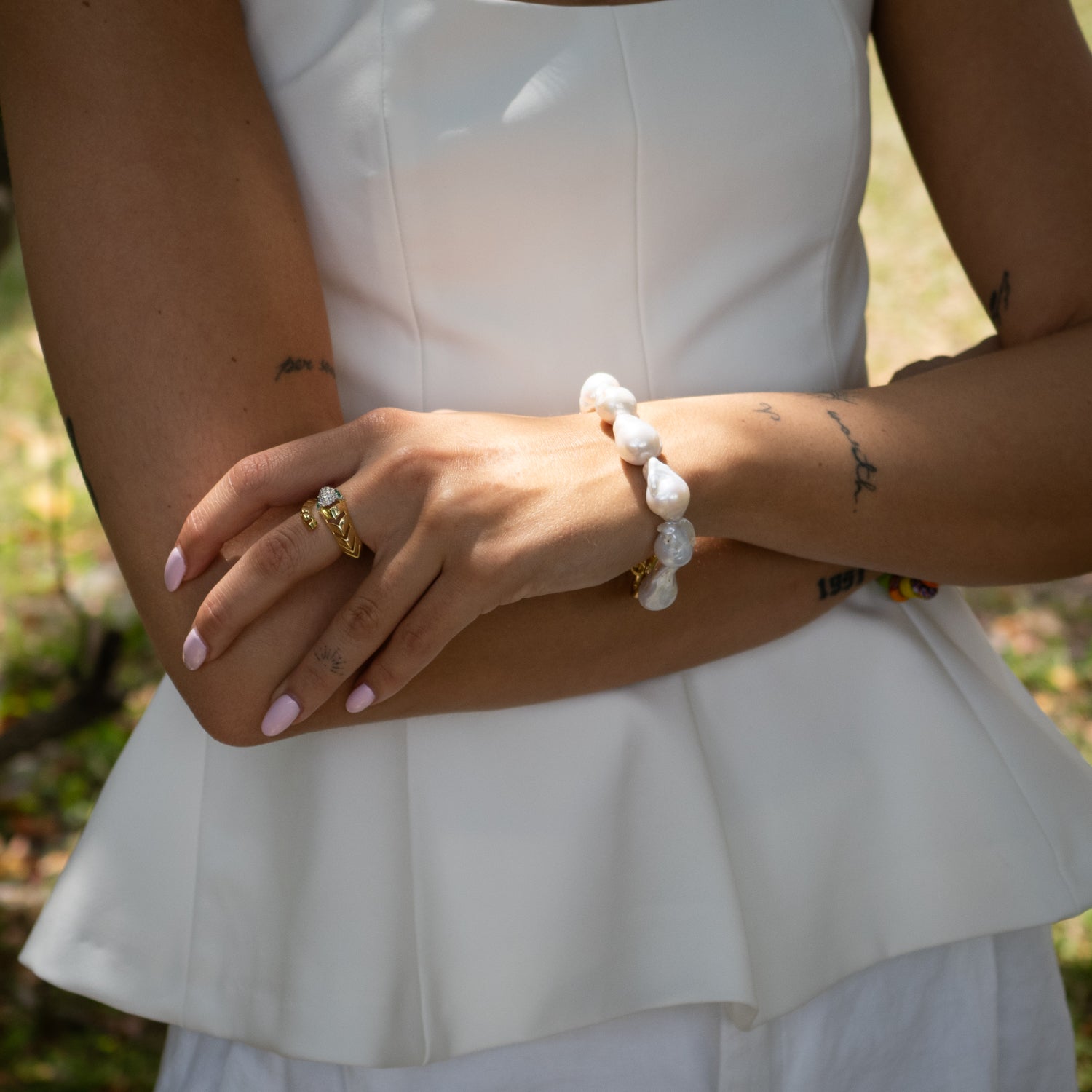 Close-up of organic-shaped pearls and textured gold clasp on handcrafted bracelet