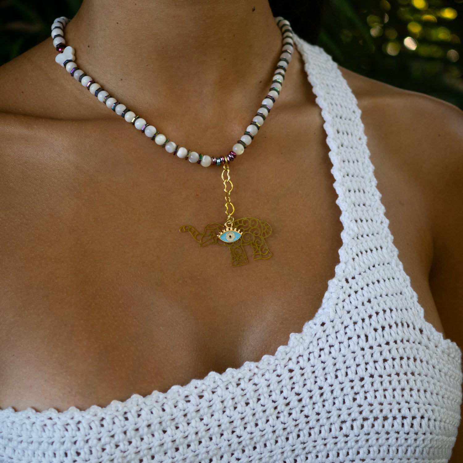 Pearl necklace with colorful hematite beads and gold-plated elephant evil eye charm for protection and luck.