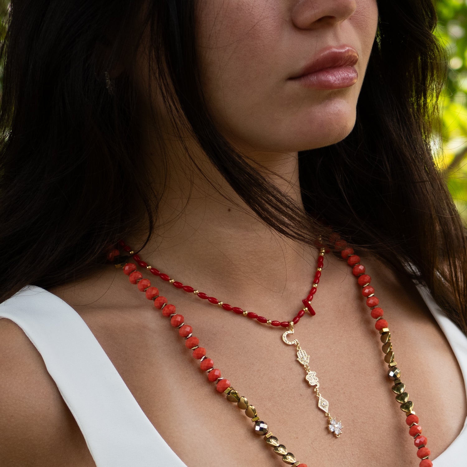 Handmade choker featuring natural red coral beads and cascading gold spiritual symbols