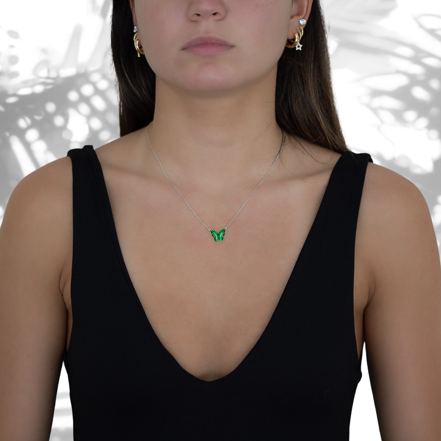 The Silver Abundance Green Enamel Butterfly Necklace complementing the model's style with elegance and transformation.