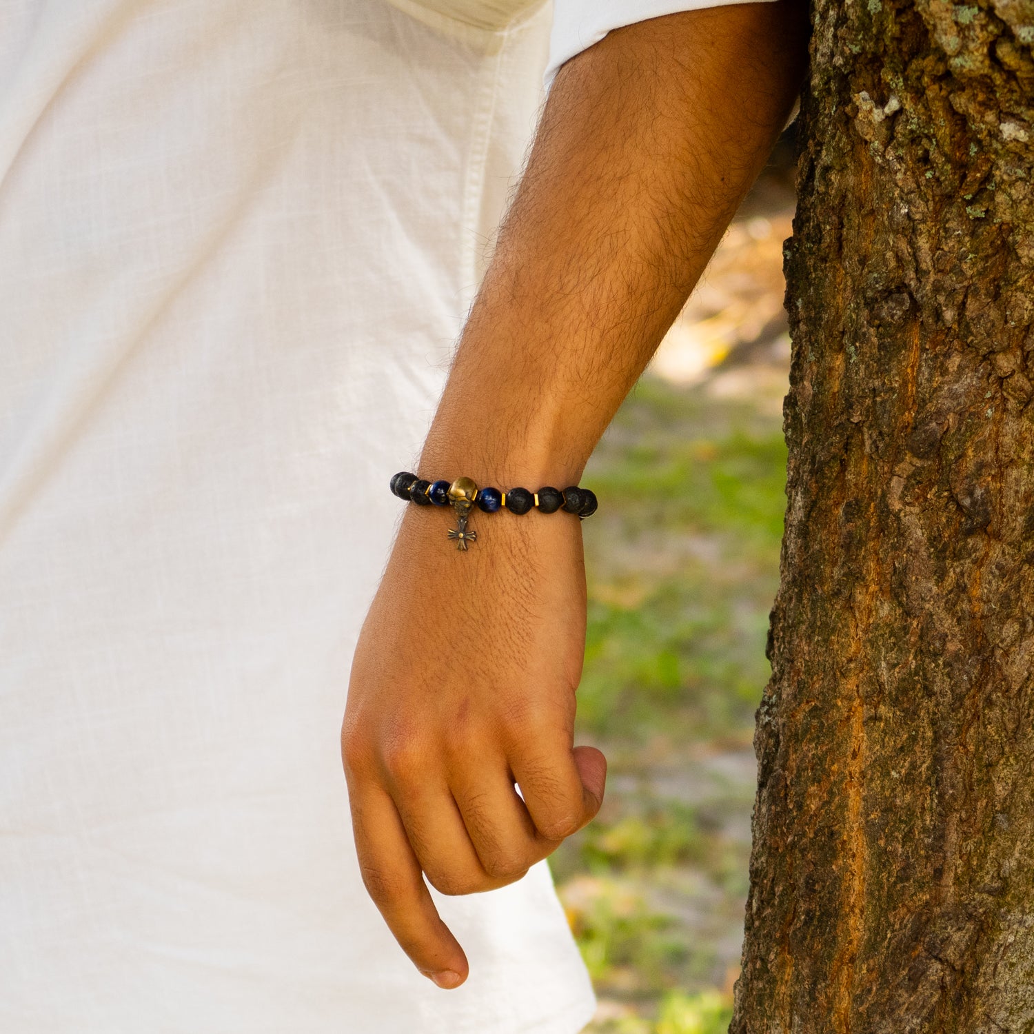 Handmade bracelet featuring lava stone, blue tiger eye, gold hematite, and gothic skull charm.