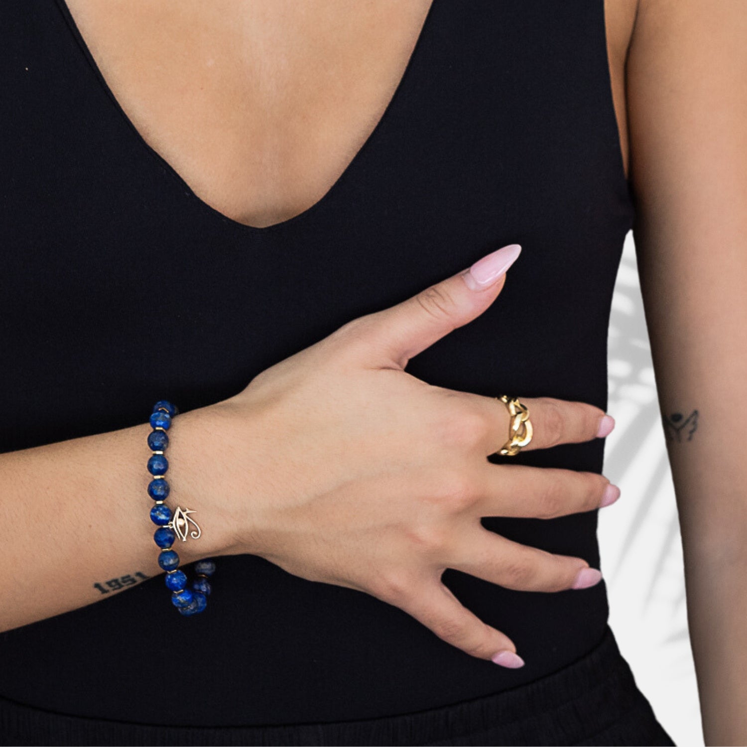 The hand model showcases the elegance and spirituality of the Solid Gold Eye of Ra Spiritual Beaded Bracelet, embodying the divine connection with the Eye of Ra symbol.