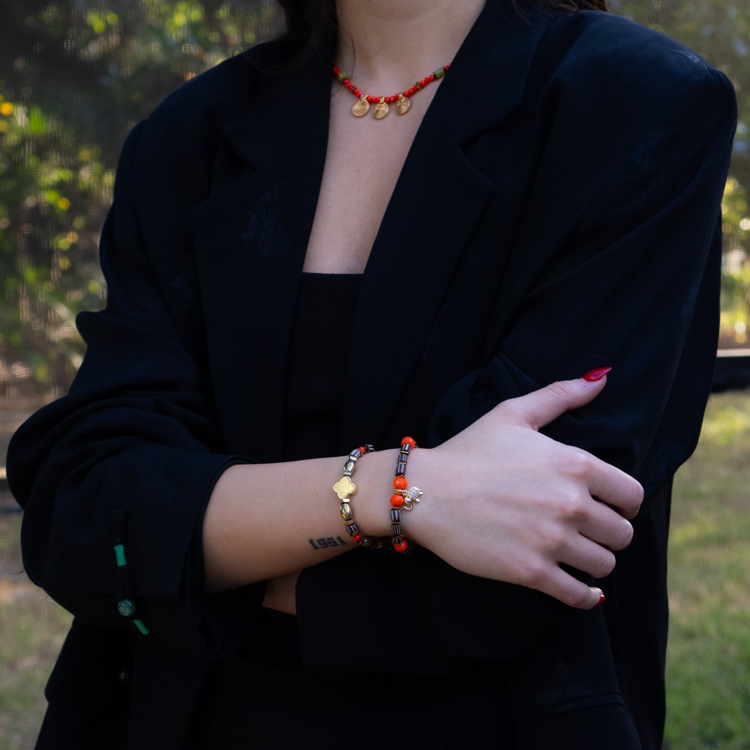 Gold and brown beaded bracelets with radiant orange and white enamel accents