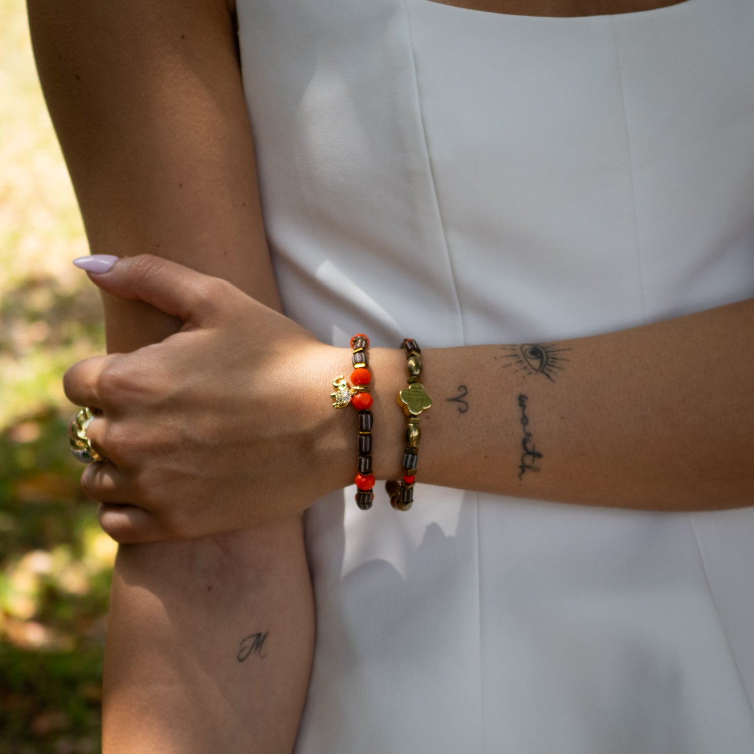 Handmade bracelet duo featuring gold-plated elephant charm and white enamel heart bead