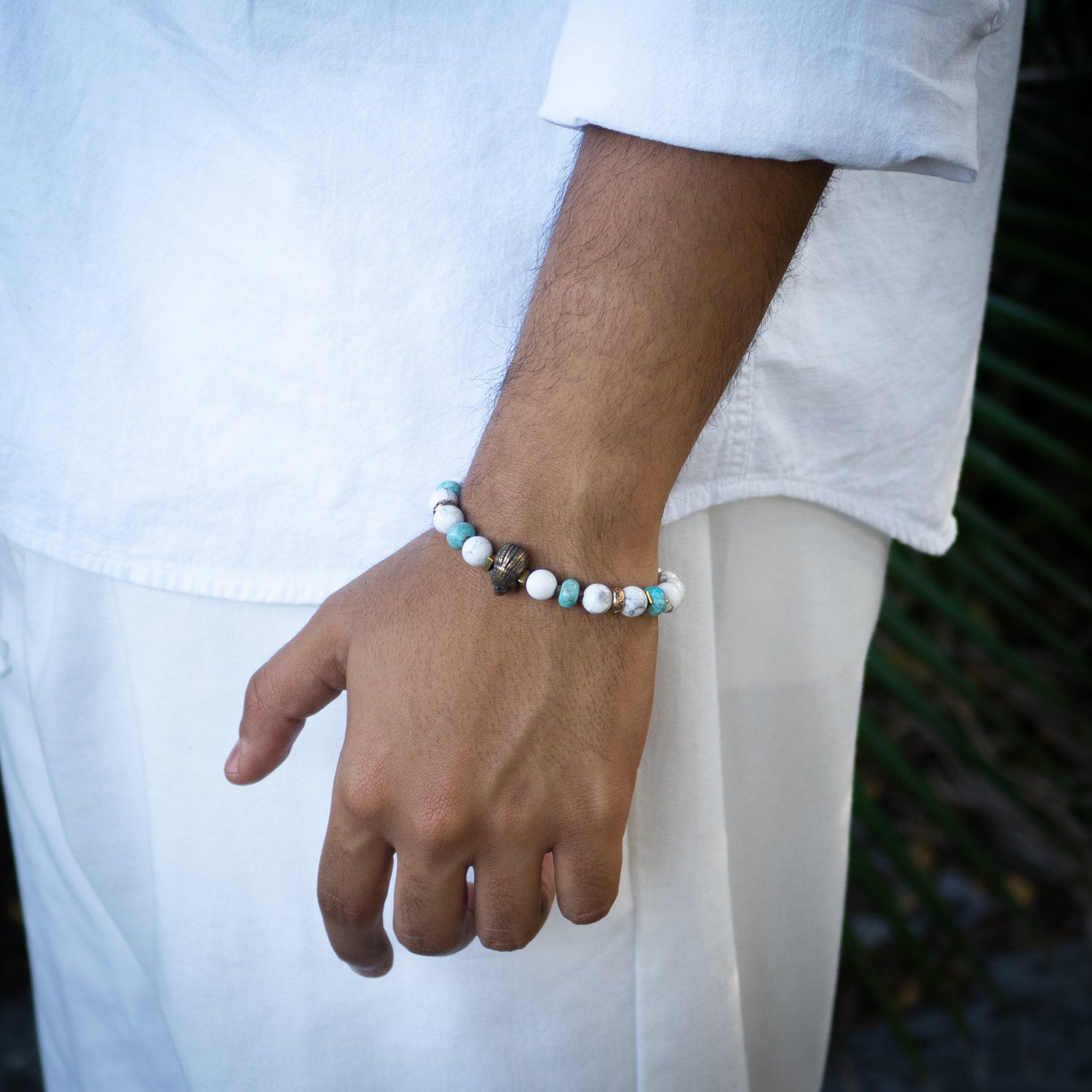 Handmade bracelet featuring turquoise, howlite stones, and gold-plated Indian centerpiece bead.