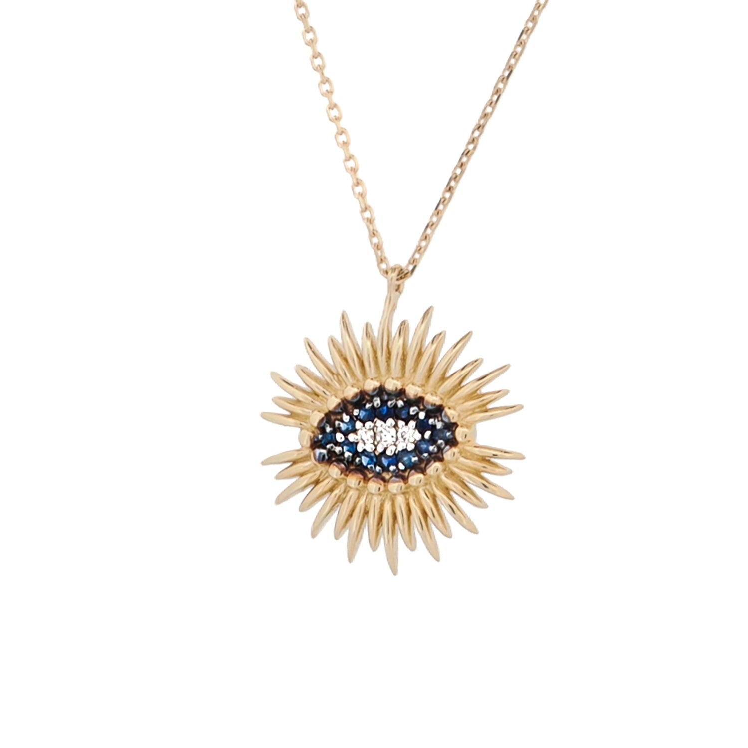 A gold-colored necklace featuring a sun-shaped pendant with a blue and clear evil eye design, surrounded by smaller sapphire stones.