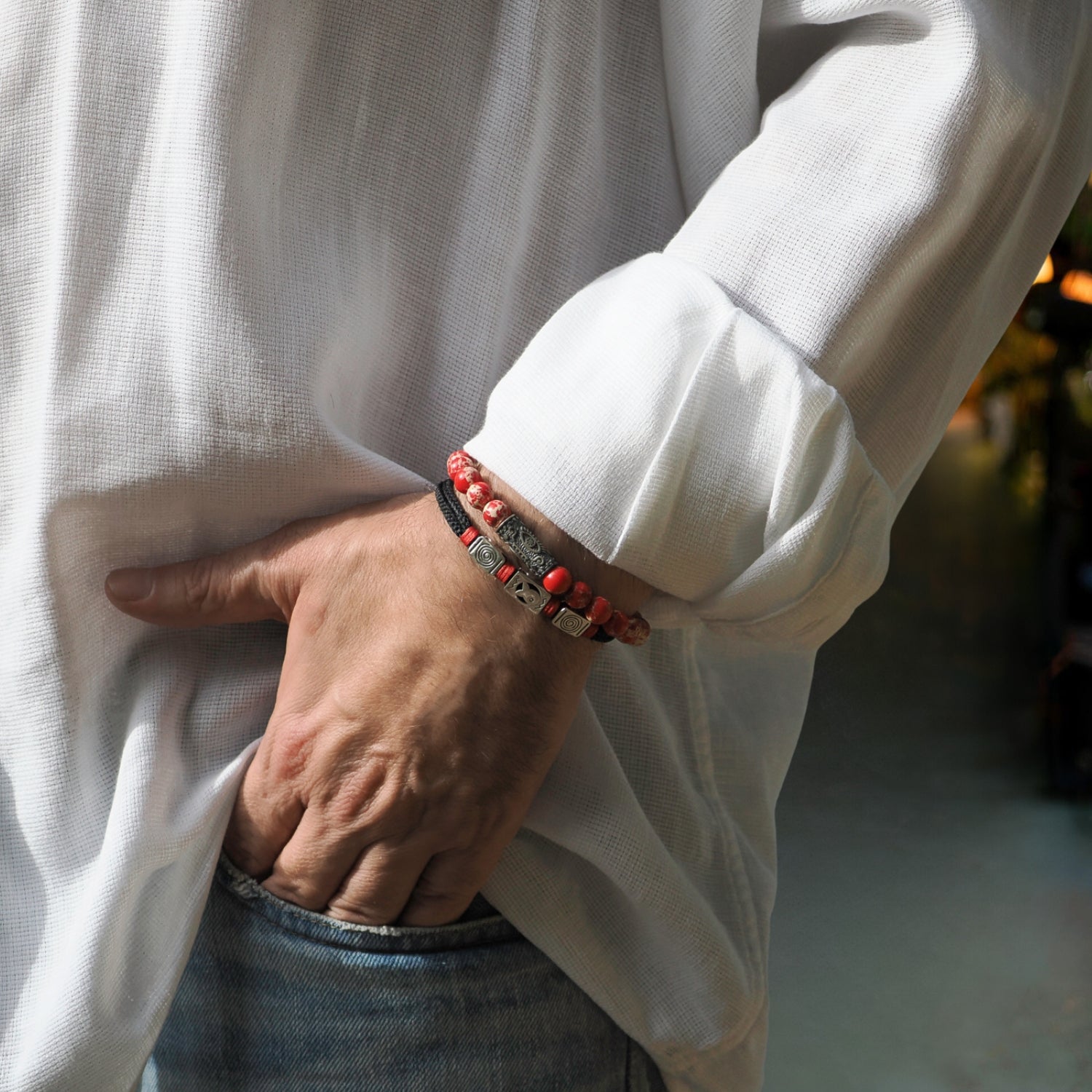 Stylish red jasper stone bracelet adorned with a sterling silver Evil Eye bead for emotional balance and strength.