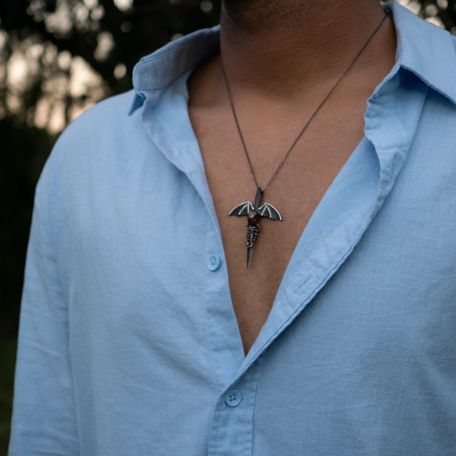 Handmade gothic necklace with ruby-eyed skull, bat wings, and zircon accents on silver chain.