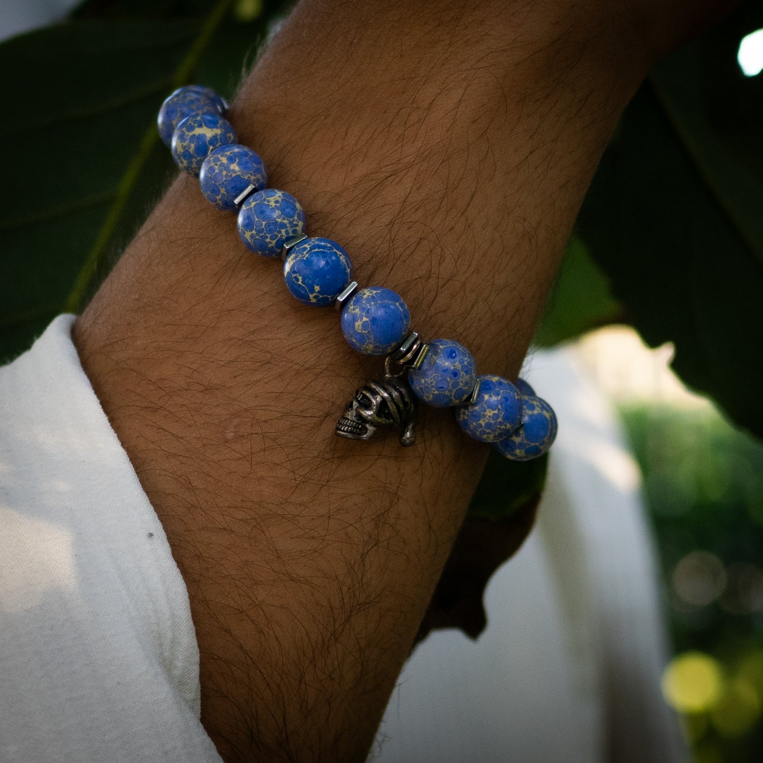 Blue Variscite beaded bracelet with sterling silver skull charm and silver hematite spacers.