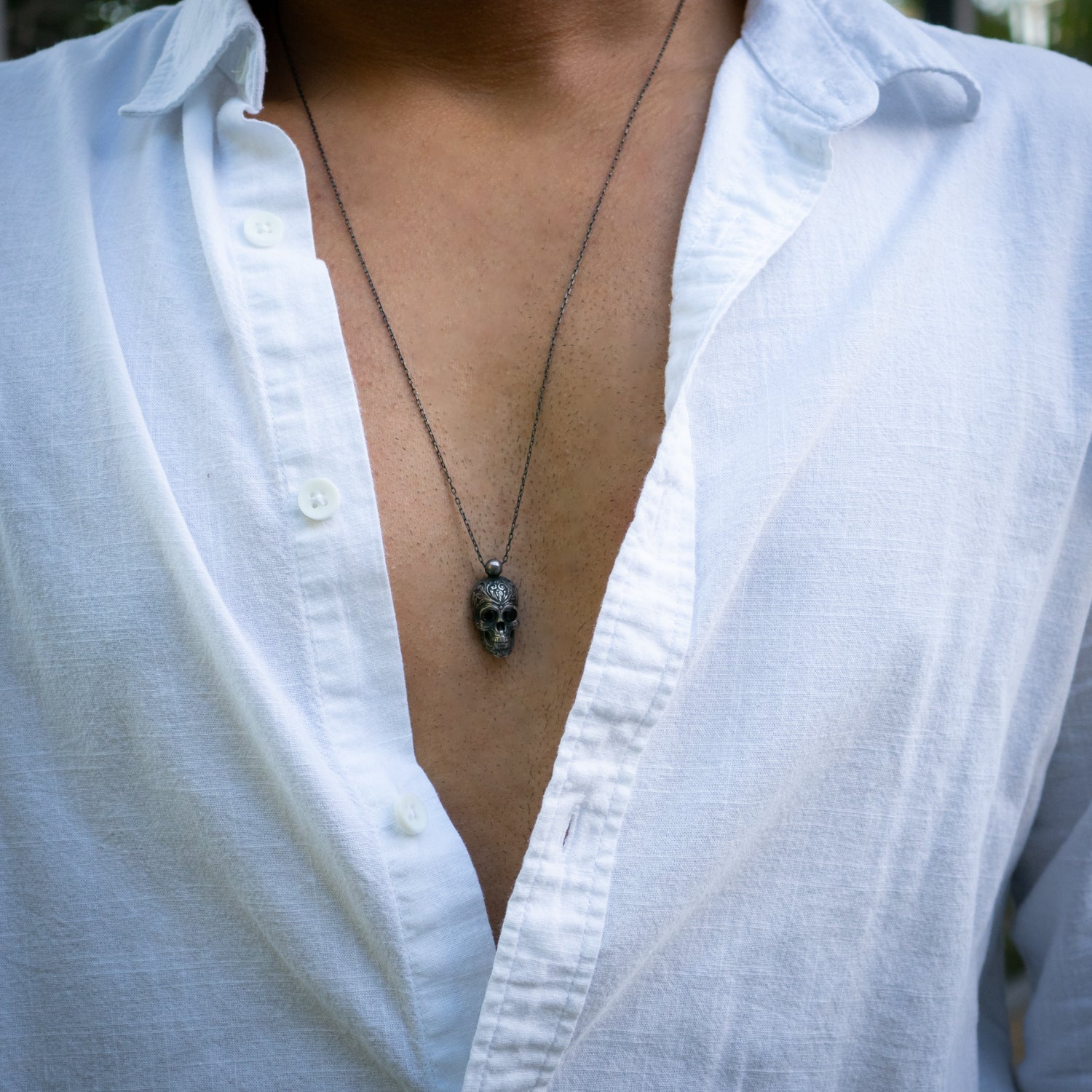 Sterling silver skull pendant necklace with dark Swarovski crystal eyes on rhodium silver chain.