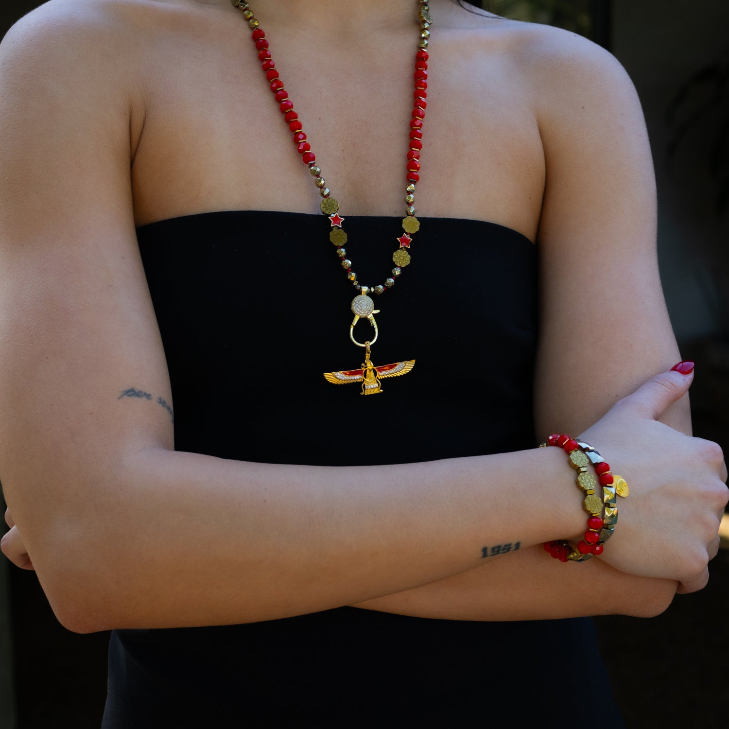 Red and gold beaded bracelet stack with flower-shaped hematite and Swarovski accents