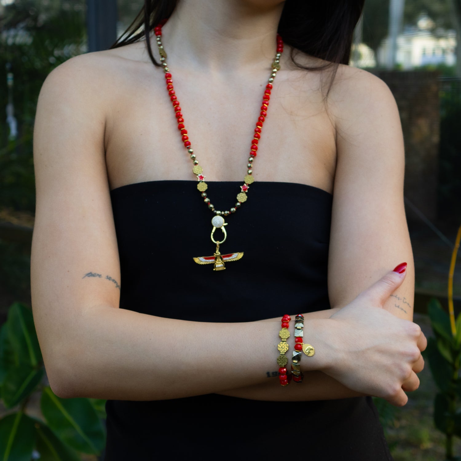 Fiery red crystal bracelet paired with gold flower accent and black Swarovski detail