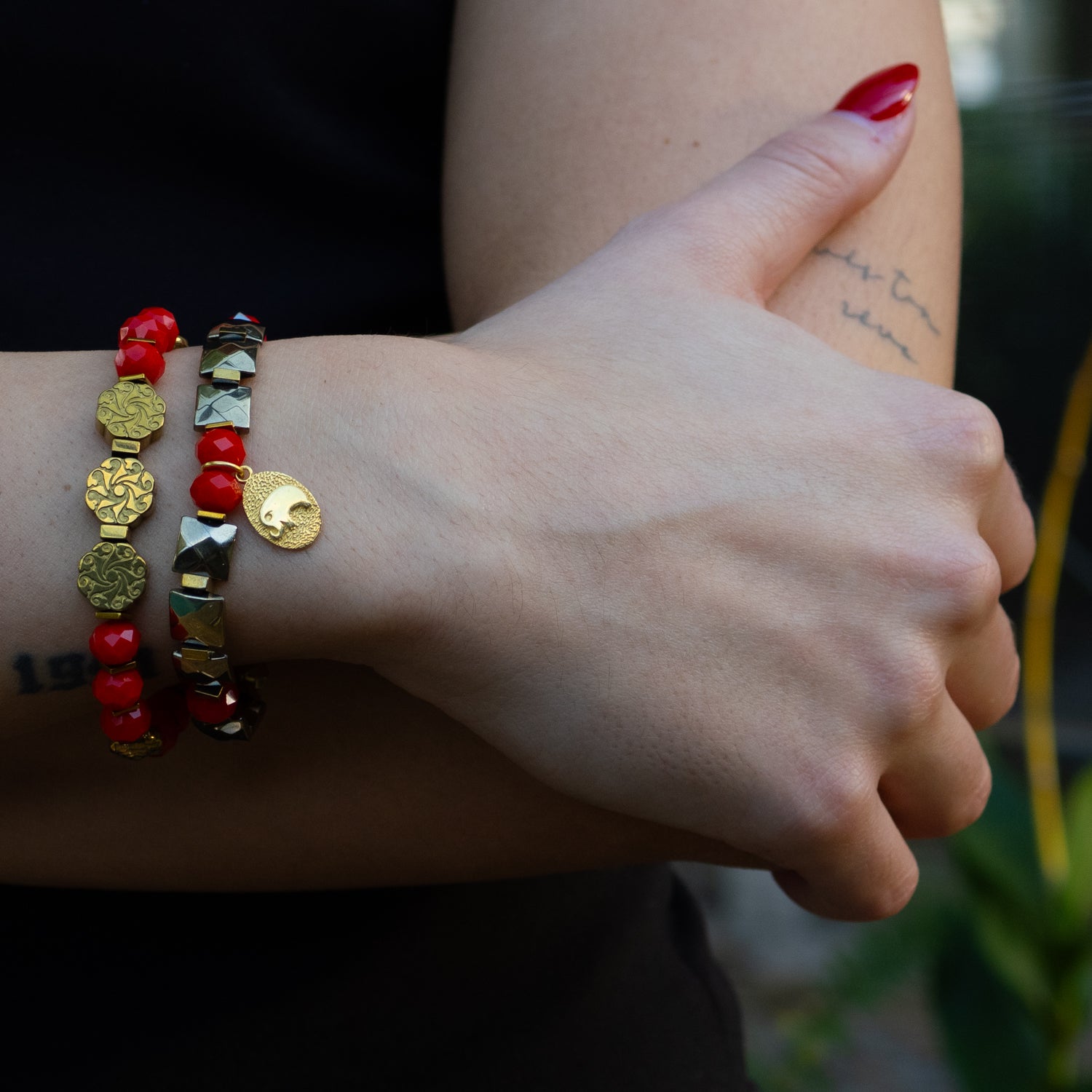 Wrist view of red energy bracelet set symbolizing power, grounding, and good fortune