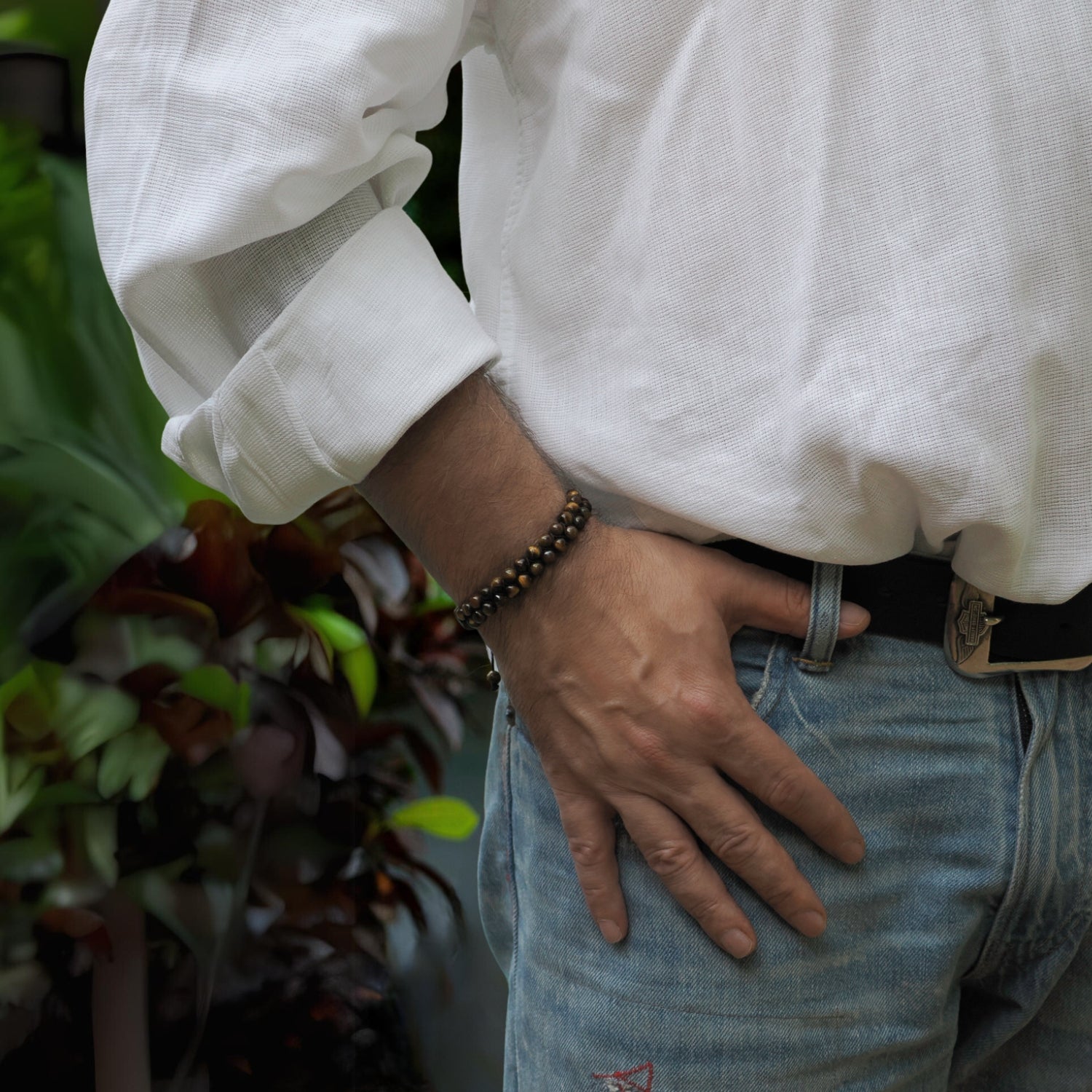 Handcrafted two-row bracelet with tiger's eye stones, silver accents, and a sliding black rope clasp.