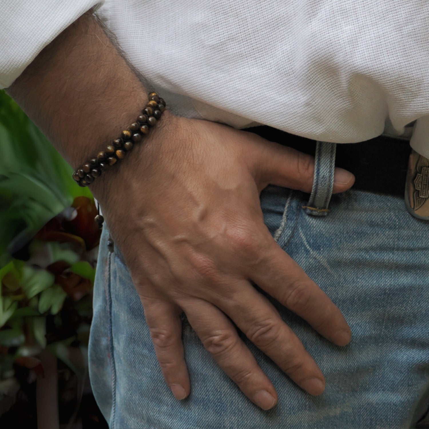 Close-up of a Tiger's Eye Beaded Bracelet with a woven black rope and sliding clasp for a custom fit.
