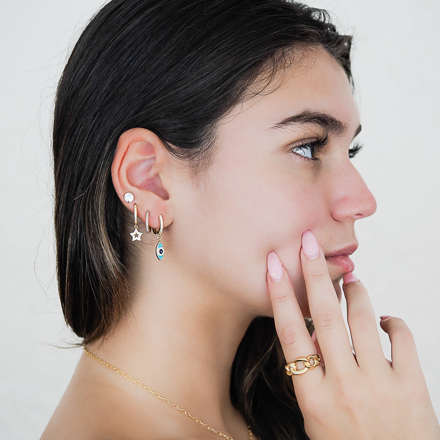 Model confidently showcasing the Turquoise Sparkly Gold Evil Eye Earrings