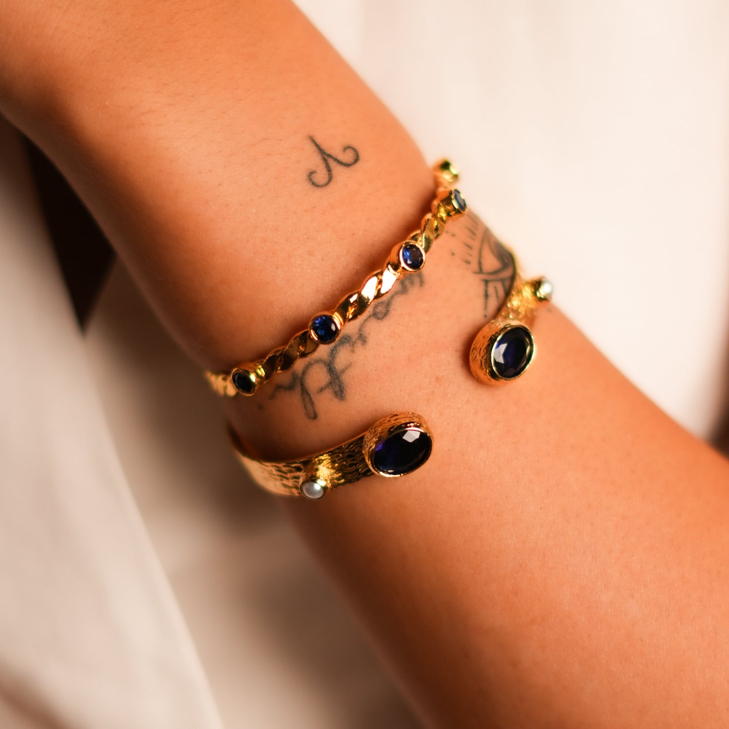 Gold Cuff Bracelet with Twisted Design and Sapphire Stones for Timeless Elegance