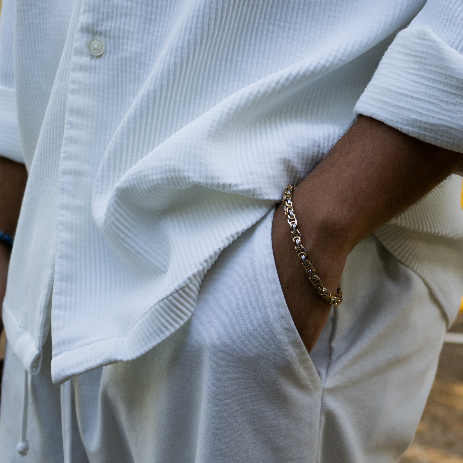 Stylish gold and silver chain bracelet for men, shown coiled with polished links and strong design.