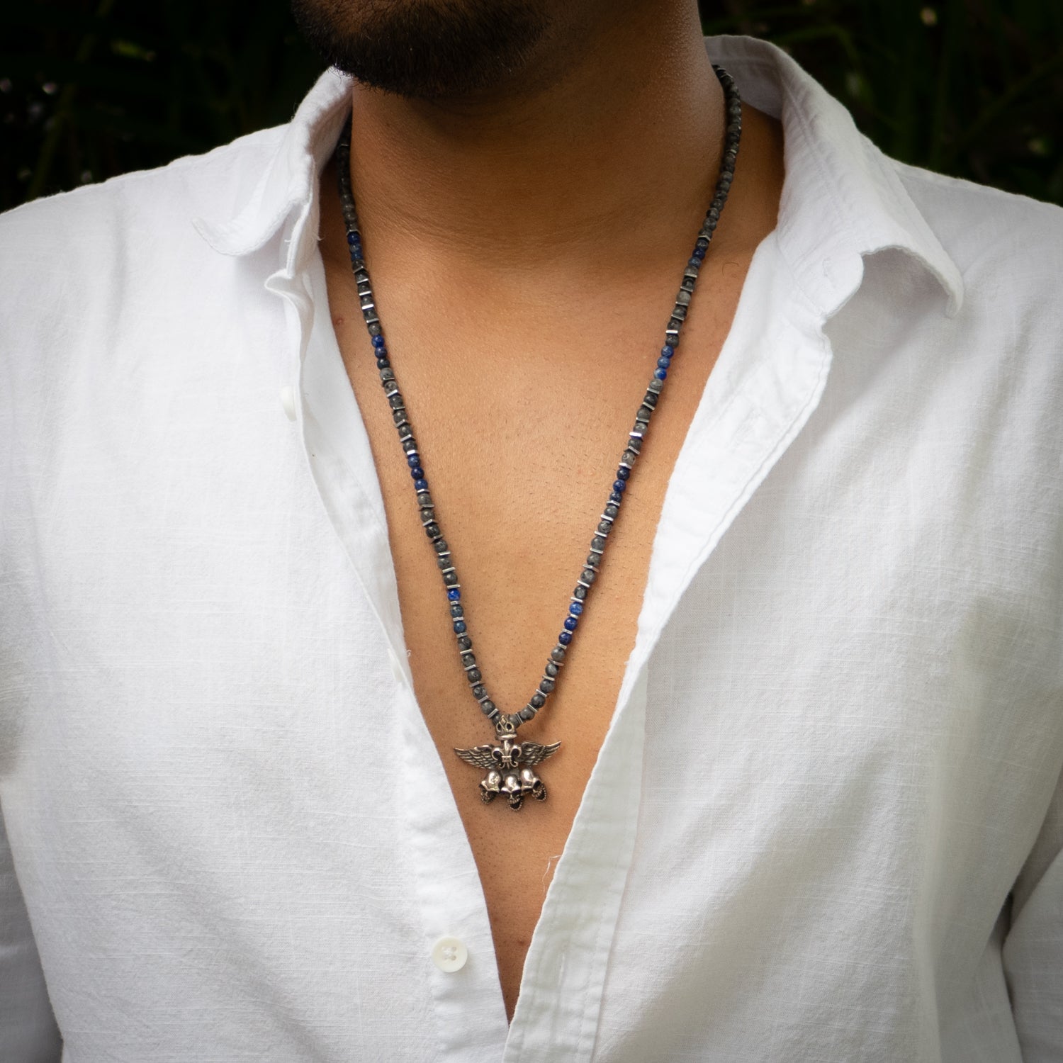 Handmade gothic necklace featuring blue lapis, obsidian beads, and silver skull with fleur de lis.