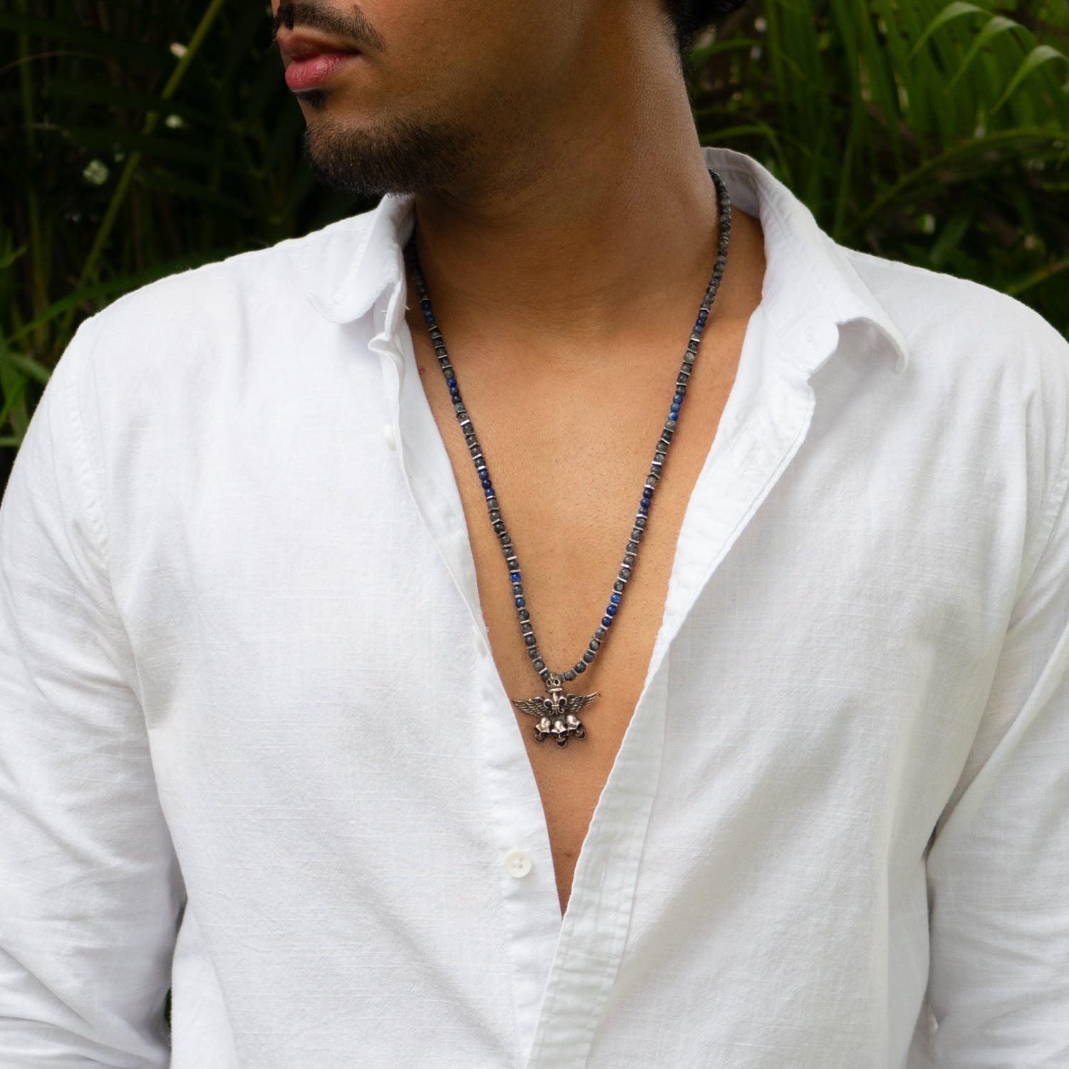 Obsidian snowflake and lapis lazuli beaded necklace with sterling silver winged skull pendant.