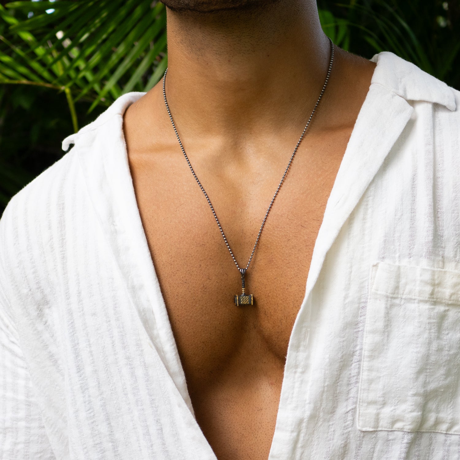 Viking-inspired pendant necklace with sterling silver chain and gold-plated hammer charm.