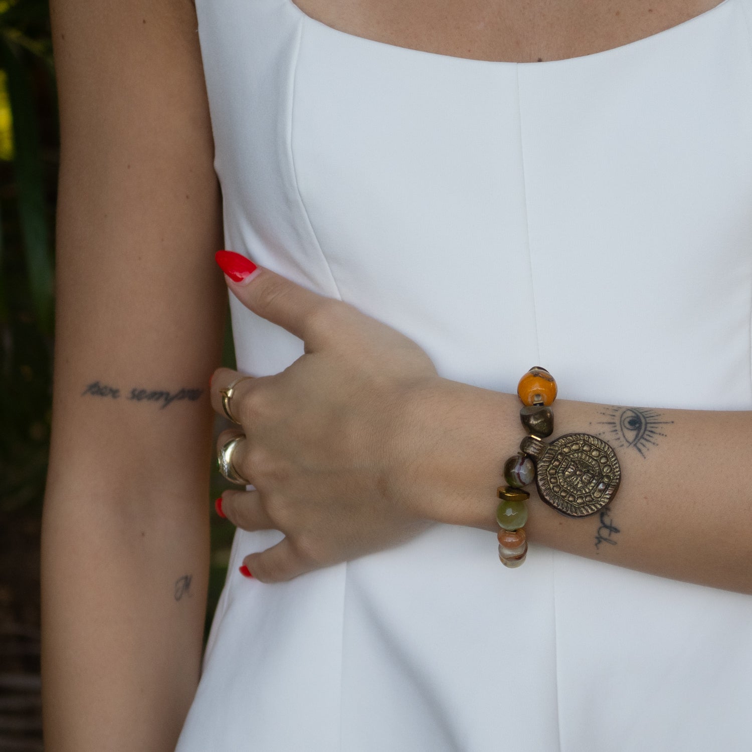 Gold color nugget hematite stone bead alongside green agate beads on a stretchy bracelet.