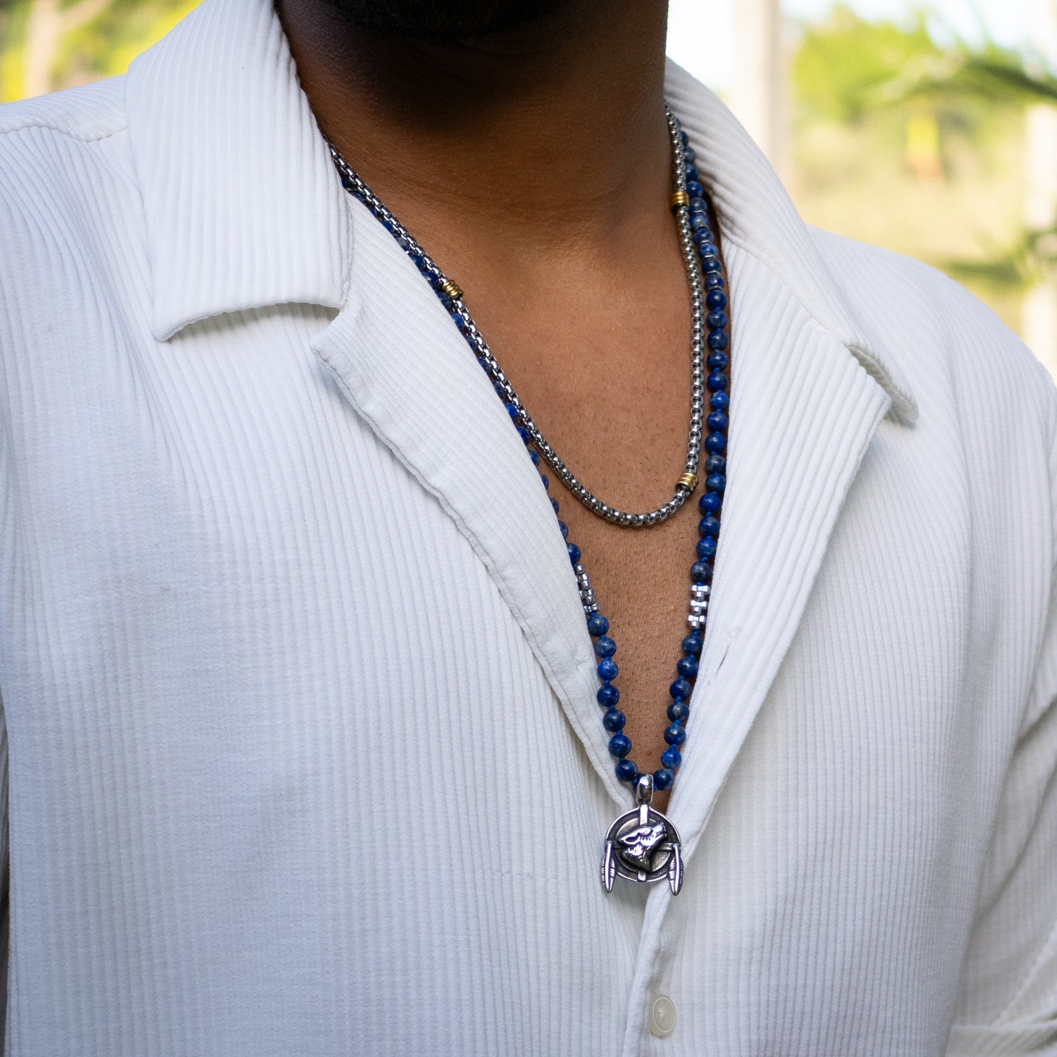 Close-up of wolf pendant necklace with vibrant lapis lazuli and silver eagle bead, handmade.