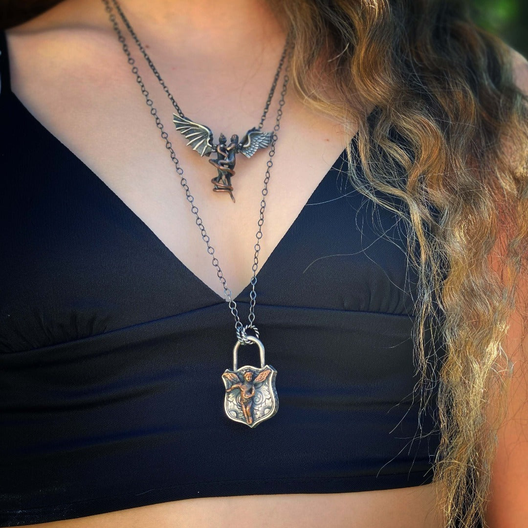 Stay protected and guided with the Angel Lock Necklace's angel charm, representing protection and guidance wearing by a model