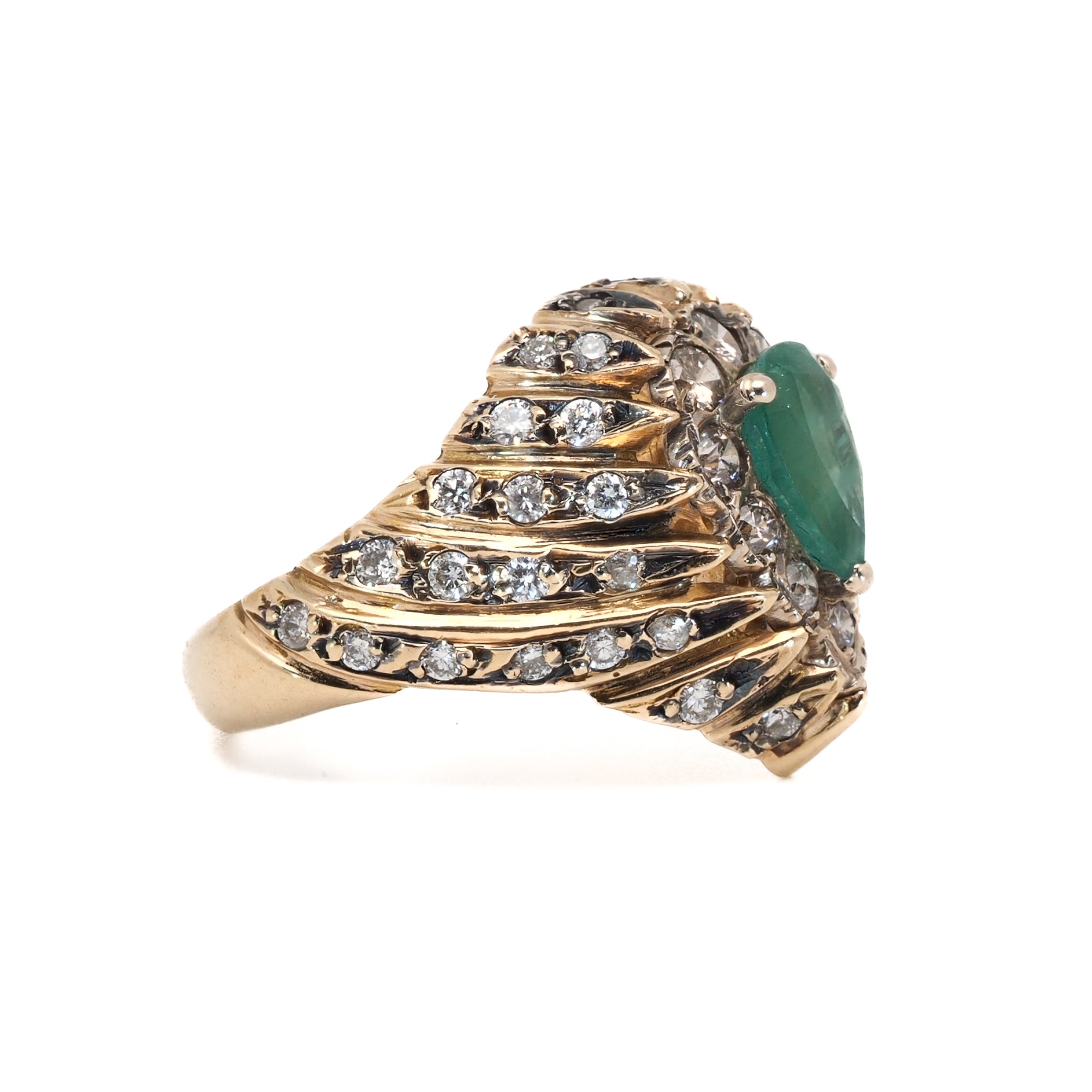 Close-up of the Emerald & Diamond Eye Ring, highlighting the vibrant green emerald and the sparkling diamonds that symbolize love and innocence.