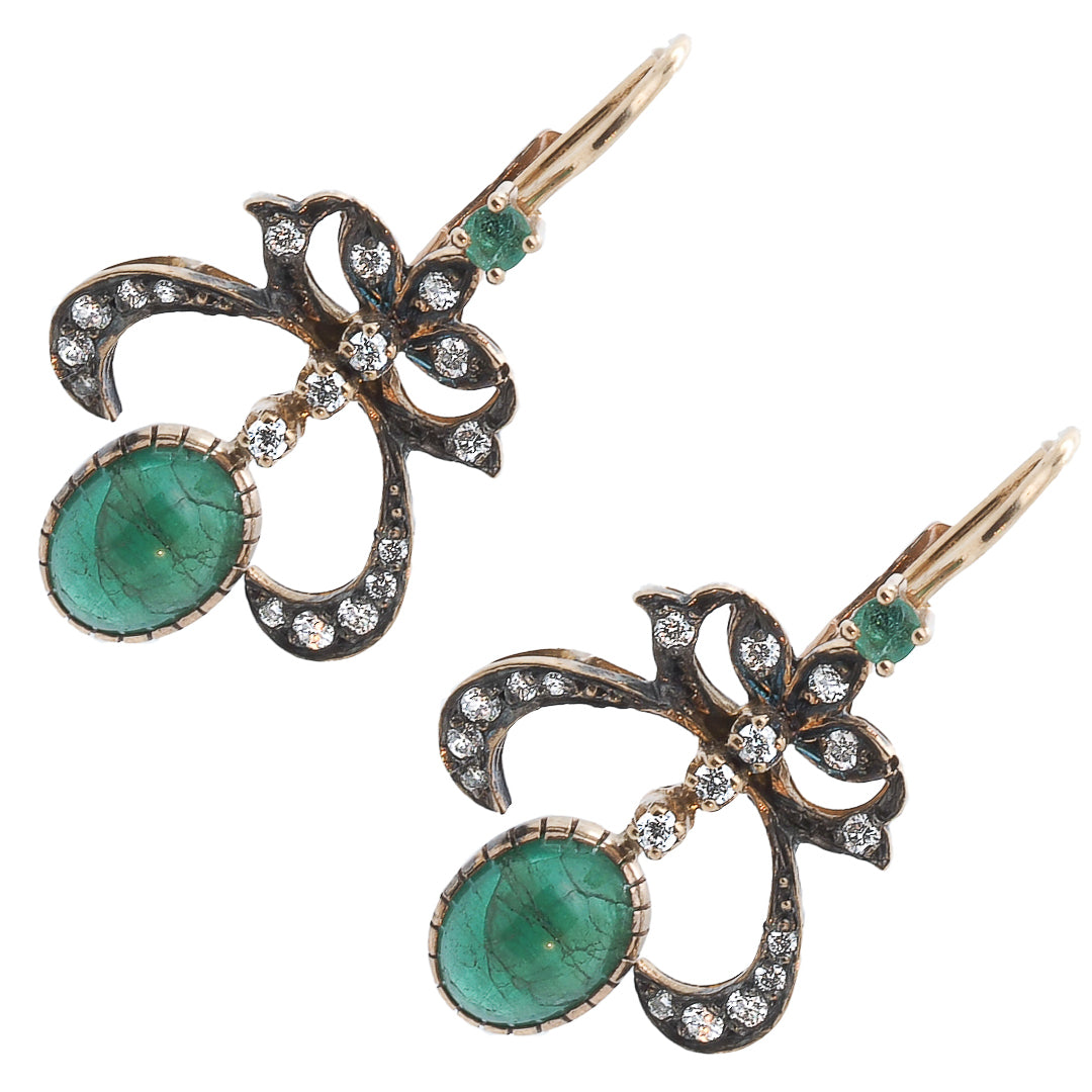A side view of Cabochon Emerald Earrings, showing off their intricate design and expertly crafted setting.