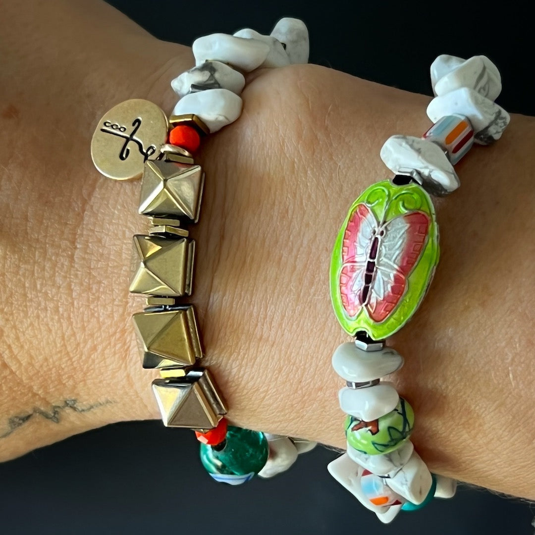 A hand model wearing the Cycle of Life Butterfly Bracelet. The bracelet adds a pop of color and spirituality to the model's wrist, creating a stylish and meaningful look.