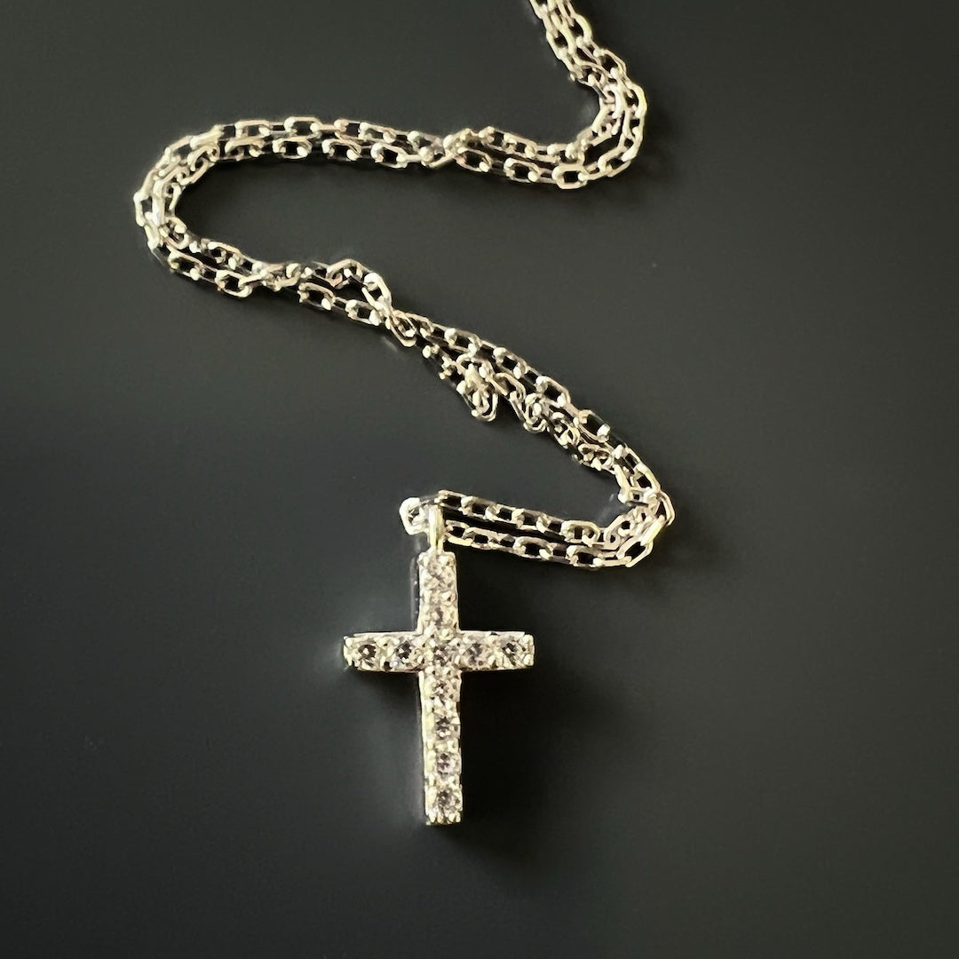 The Dainty Diamond Cross Necklace in 18K gold plated version. The necklace adds a touch of luxury and sophistication to any outfit, with the cross pendant adorned with a sparkling CZ diamond.
