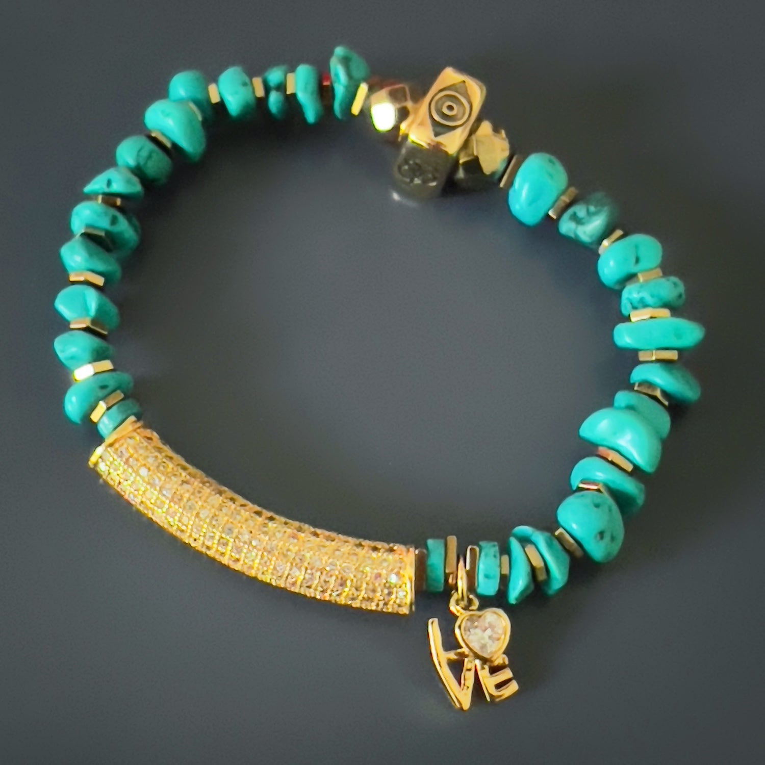 the Diamond and Turquoise Love Bracelet, showcasing its stunning combination of natural nugget turquoise stone beads, gold hematite spacers, and a gold plated charm with a simulated diamond.