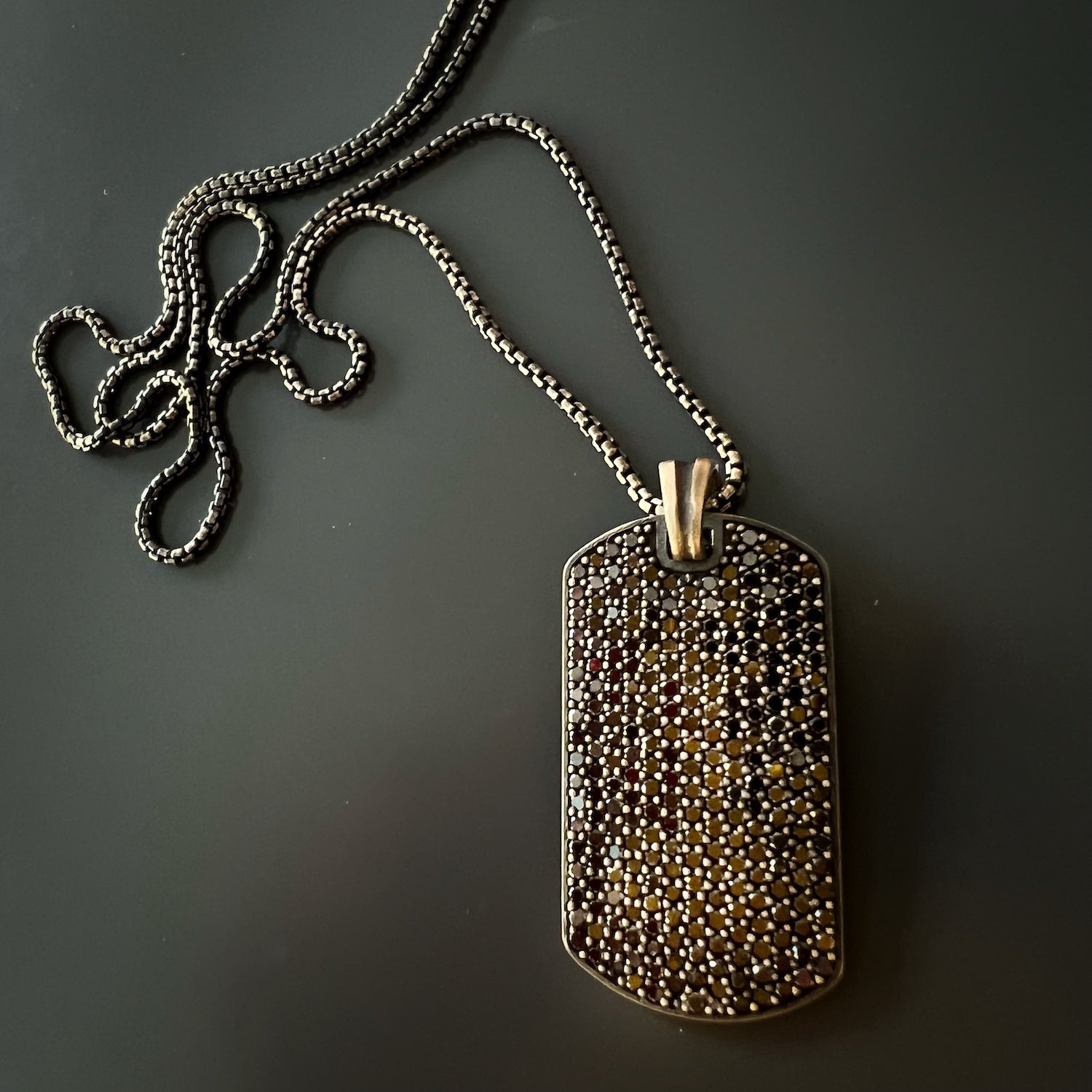 The Dog Tag Black Diamond Necklace displayed on a jewelry stand, allowing for a full view of its captivating design and craftsmanship.