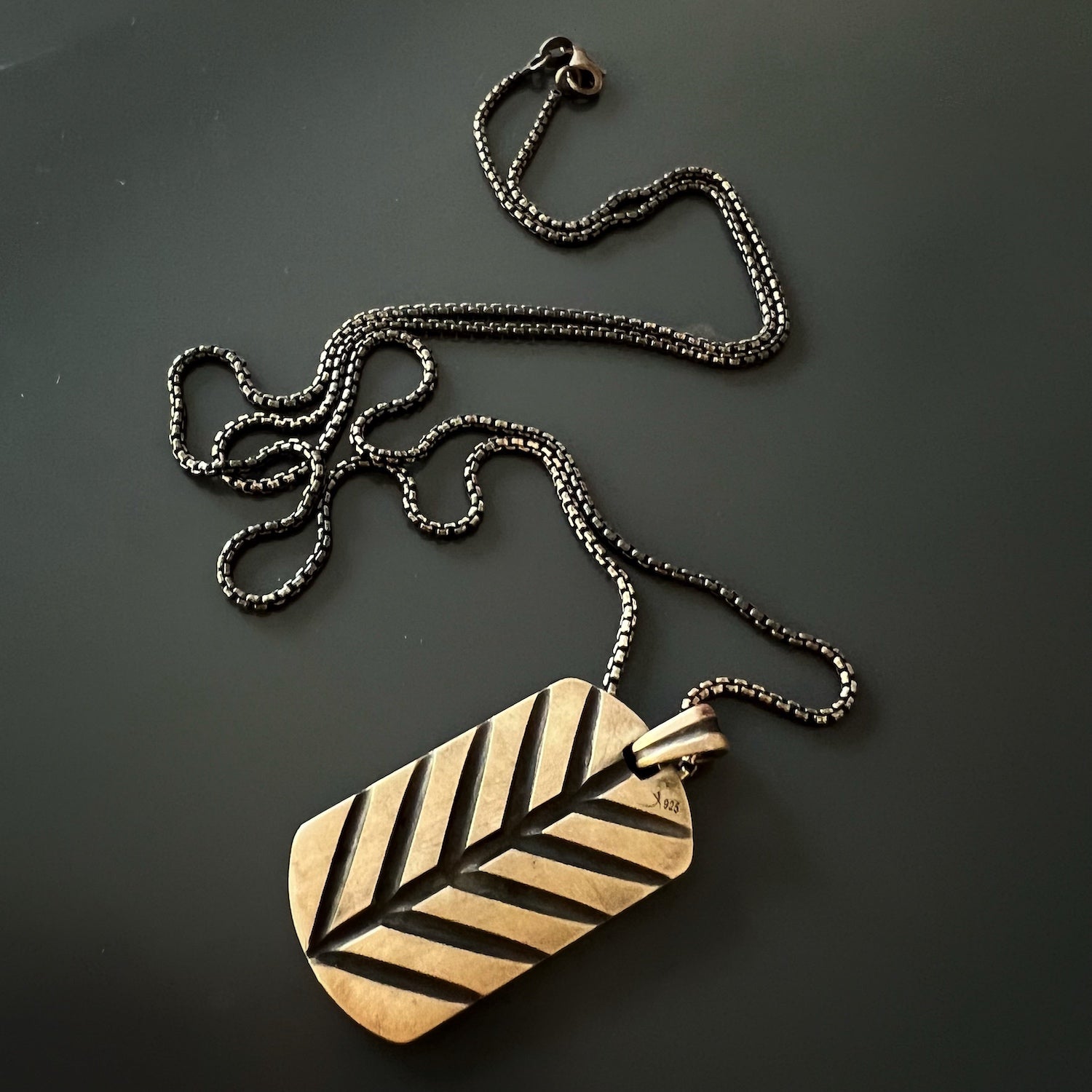 Side view of the necklace, showcasing the long 30-inch sterling silver chain that adds an elegant touch to the overall look.