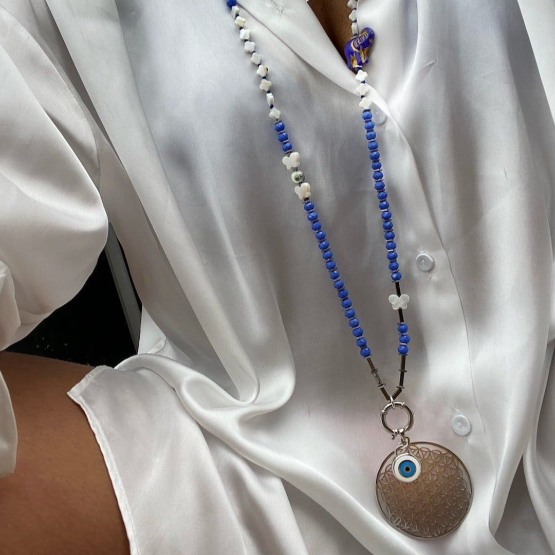 Model wearing Sacred Geometry-inspired Flower of Life Necklace - Unique jewelry piece with a 925 Solid Silver pendant, blue crystal beads, and silver hematite spacers, representing interconnectedness and grace.