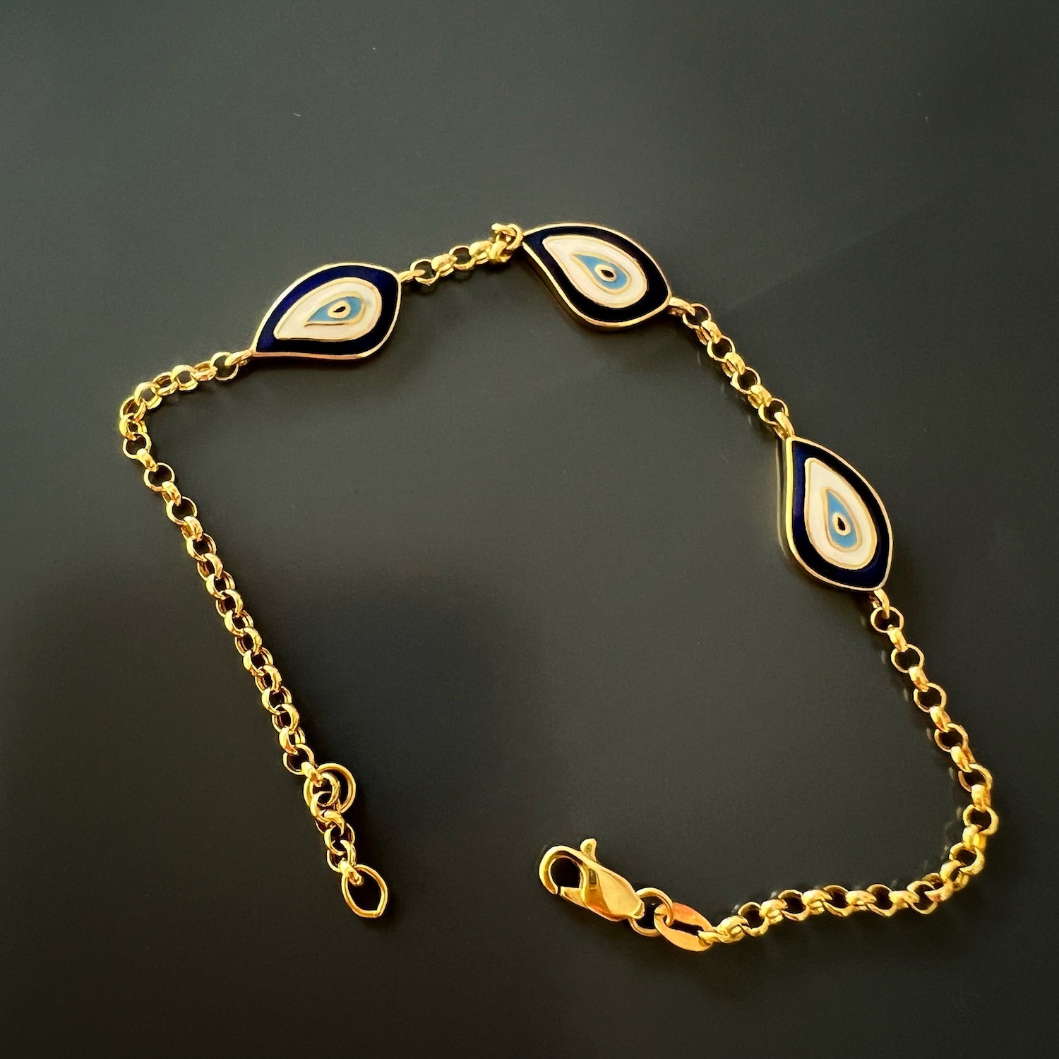 Handcrafted Gold Evil Eye Bracelet - An artistic image highlighting the intricate craftsmanship of the Gold Teardrop Lucky Evil Eye Bracelet, featuring the delicate evil eye charms and vibrant blue enamel.