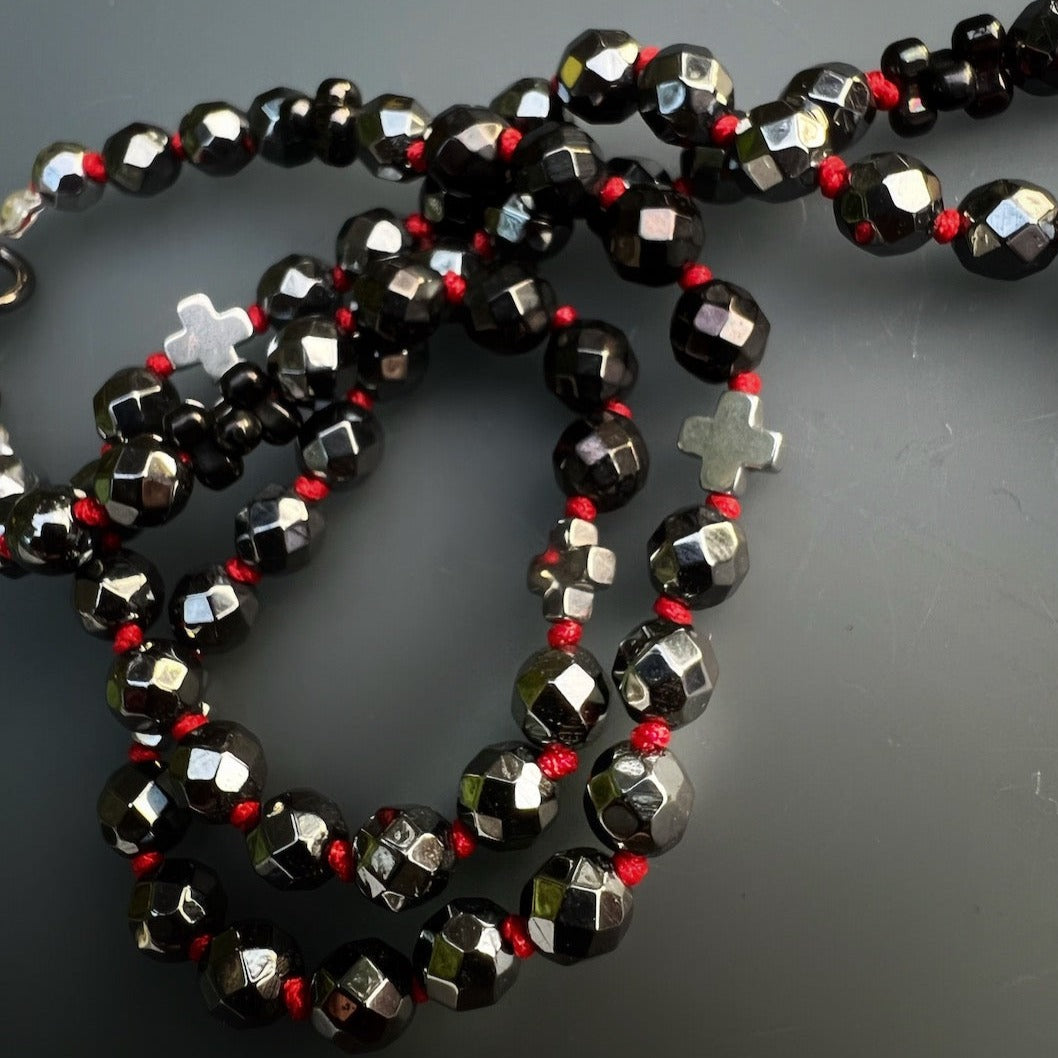 Unique handmade necklace with hematite beads and a steel skull pendant embellished with red zircon crystals