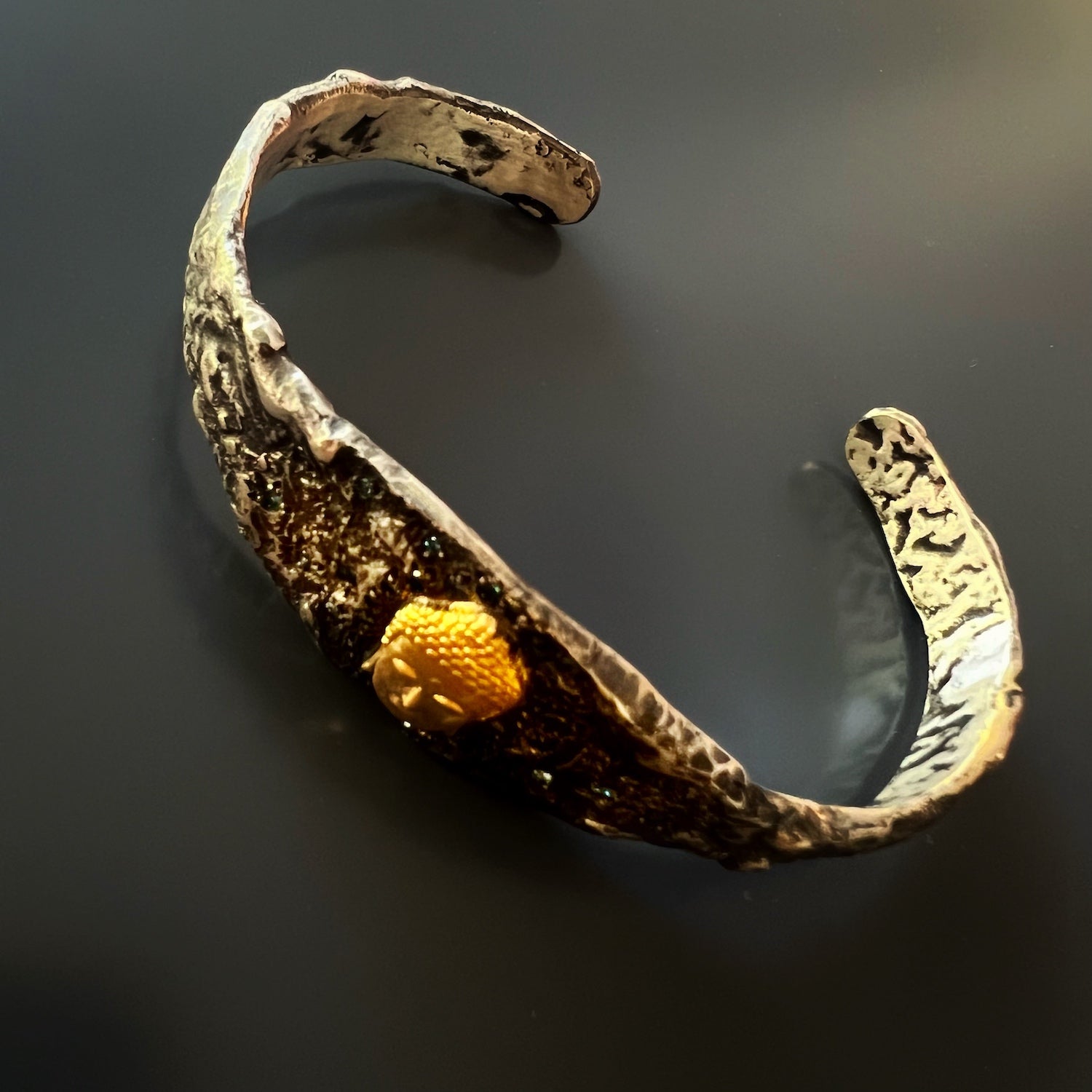 Luxurious Buddha Bangle Bracelet - This handcrafted bracelet showcases a combination of 14k yellow gold, blue diamonds, and sterling silver, creating a truly unique and opulent piece of jewelry.