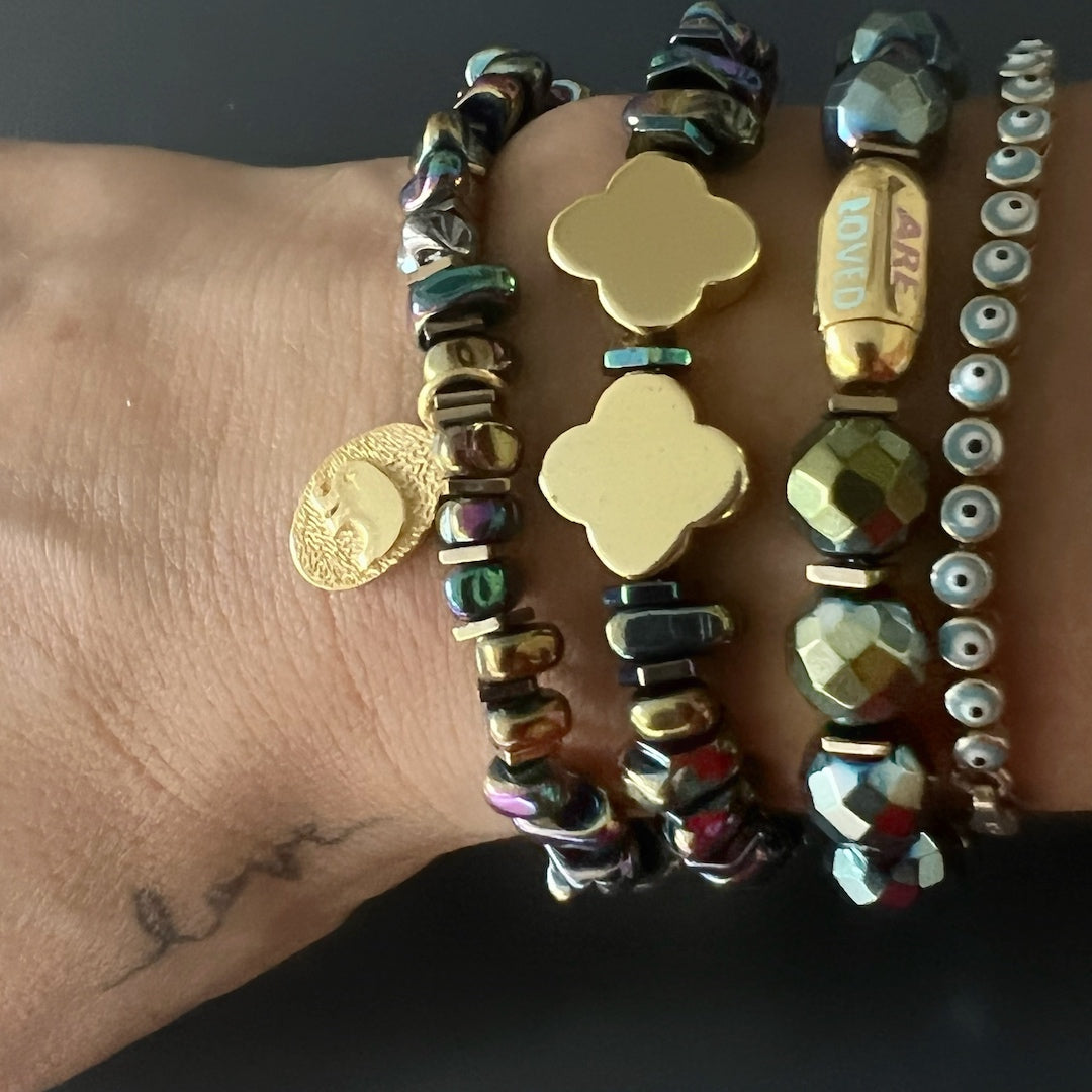 Hand model wearing the Hematite Floral Bracelet, showcasing its elegance and style with multicolor Hematite beads and gold floral accents.