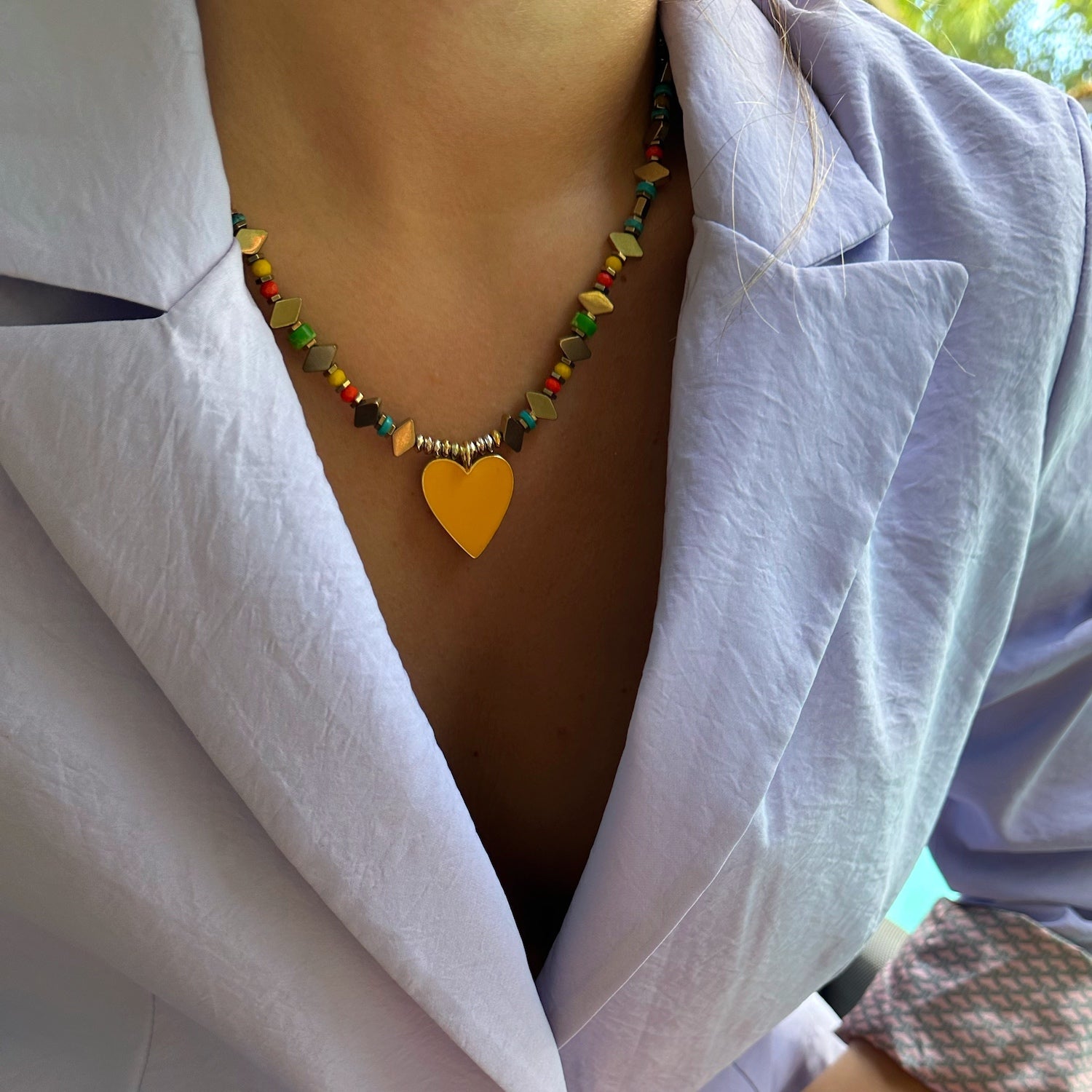 The Joyful Heartbeat Necklace beautifully adorning the neck of a model, bringing a pop of color and radiating positivity.