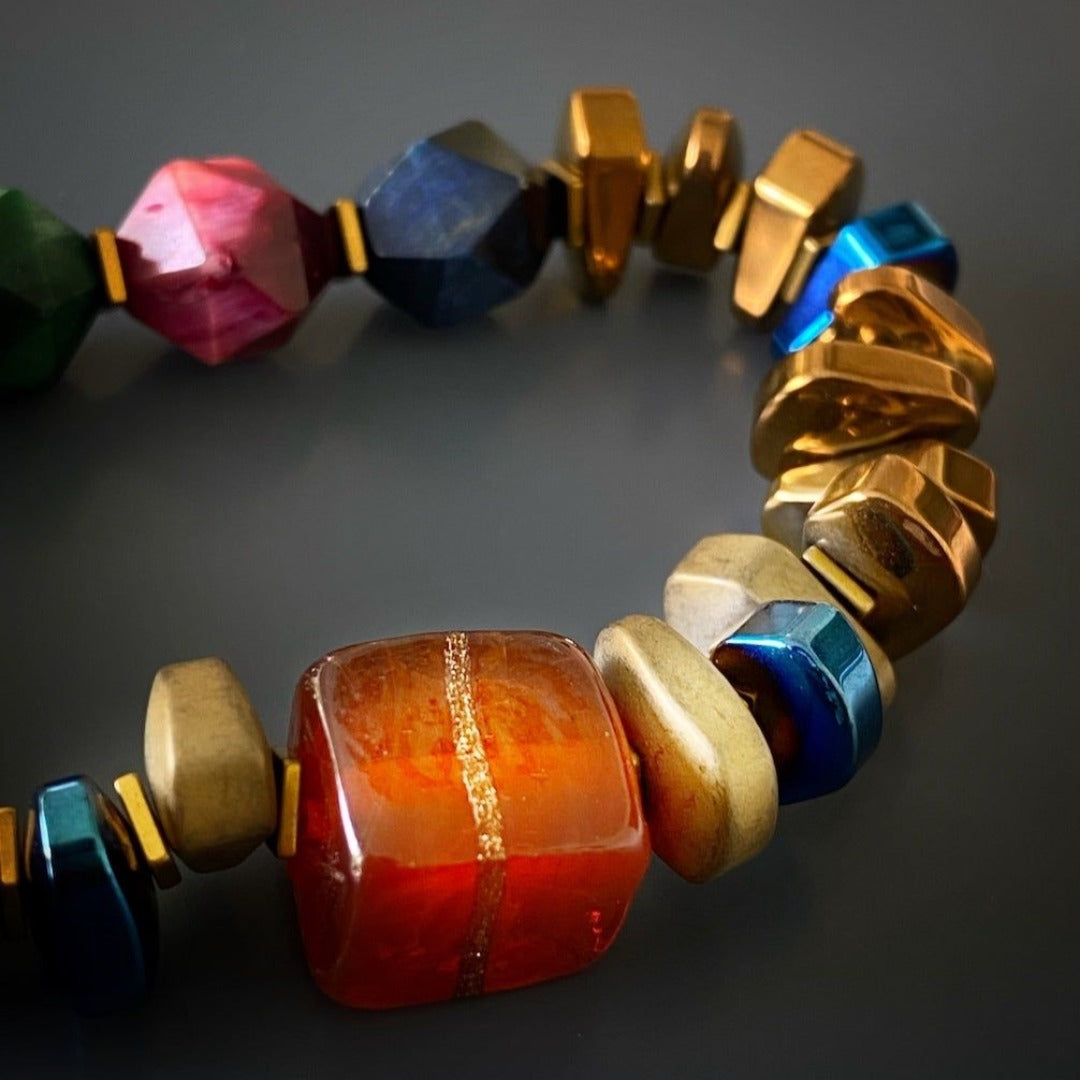The Karma Hematite Bracelet, a symbol of balance and healing, with its vibrant jasper stone and elegant combination of gold and blue hematite beads.