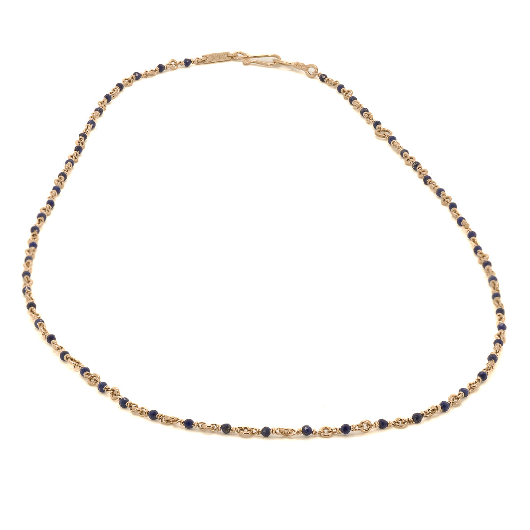The Karya Lapis Gold Necklace beautifully catches the light, showcasing the rich colors and luxurious shine of the lapis lazuli gemstones.