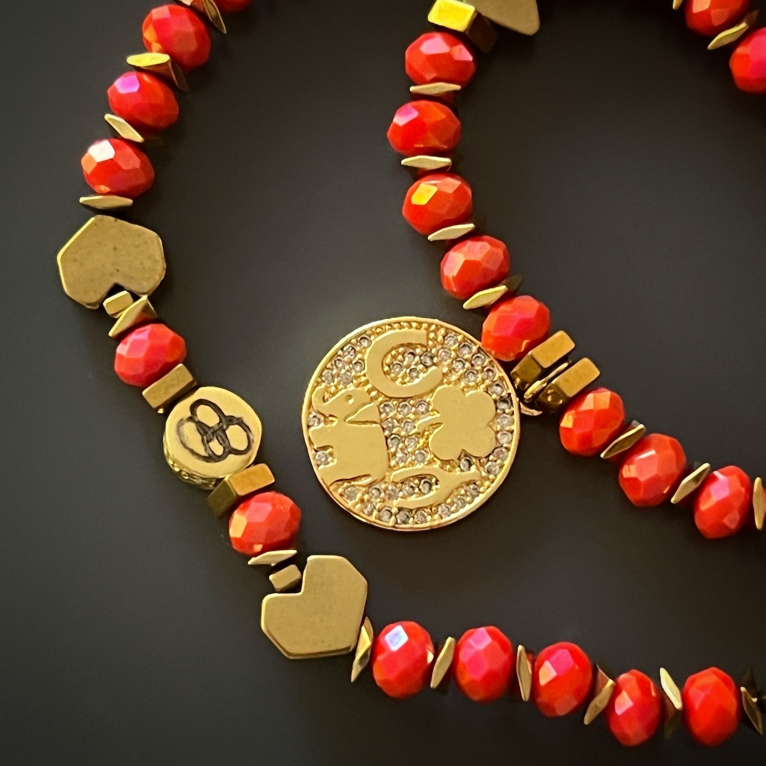 Add a touch of elegance to your wrist with the Lucky Symbol Bracelet, handmade with gold hematite spacers and a beautiful orange crystal bead design.