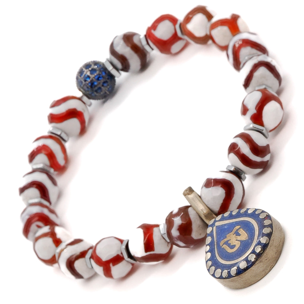Elevate your style with the Maya Bracelet, a handmade accessory featuring Striped Nepal Agate, Silver Hematite, and an exquisite Om Mantra charm.