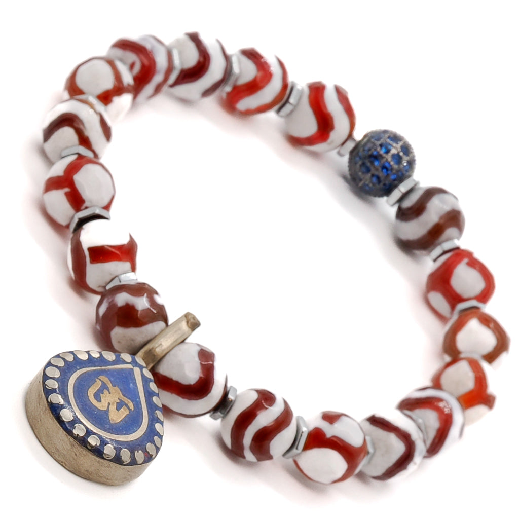 Embrace the celestial energies of the Maya Bracelet, adorned with Striped Nepal Agate, Silver Hematite spacers, and a captivating Ethnic Om Mantra charm.